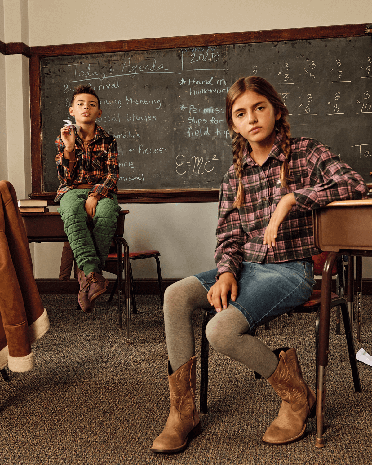 Two kids in a classroom, one wearing a plaid shirt and the other in a Midi Denim Skirt, both engaged in learning.