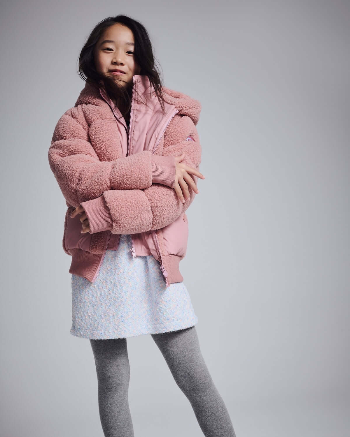 Girl wearing a Pink Teddy Puffer Coat, showcasing its cozy design and stylish look in cold weather.