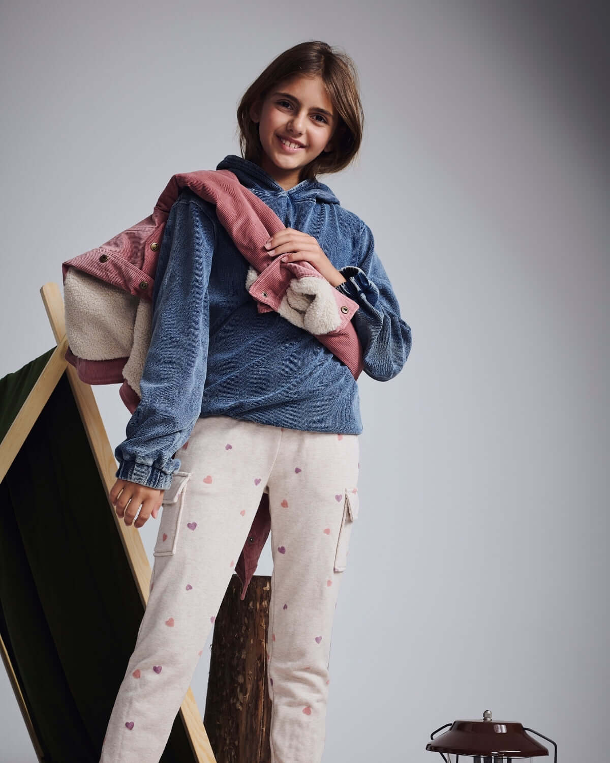 Girl wearing Dusk Blue Pullover Hoodie with pink jacket and cream pants, showcasing a stylish and cozy outfit.