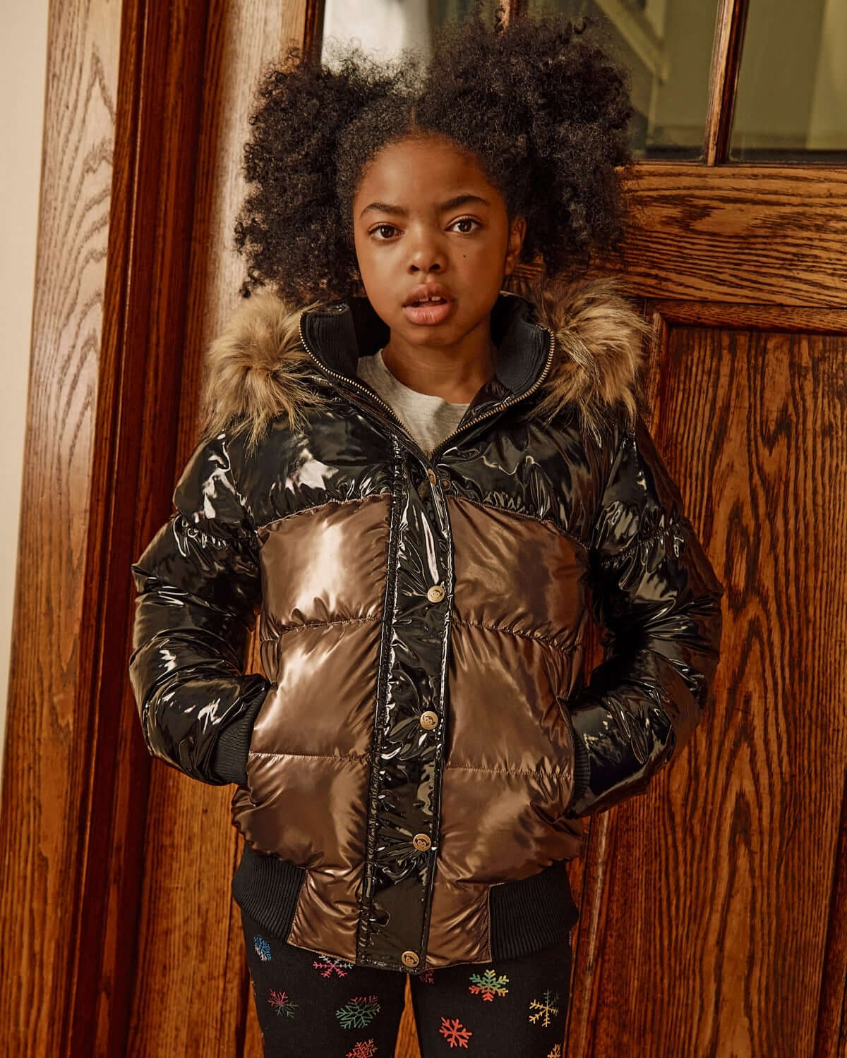 Copper Shine Kyla Puffer Coat worn by a girl, featuring shiny exterior and faux fur trim, perfect for winter adventures.