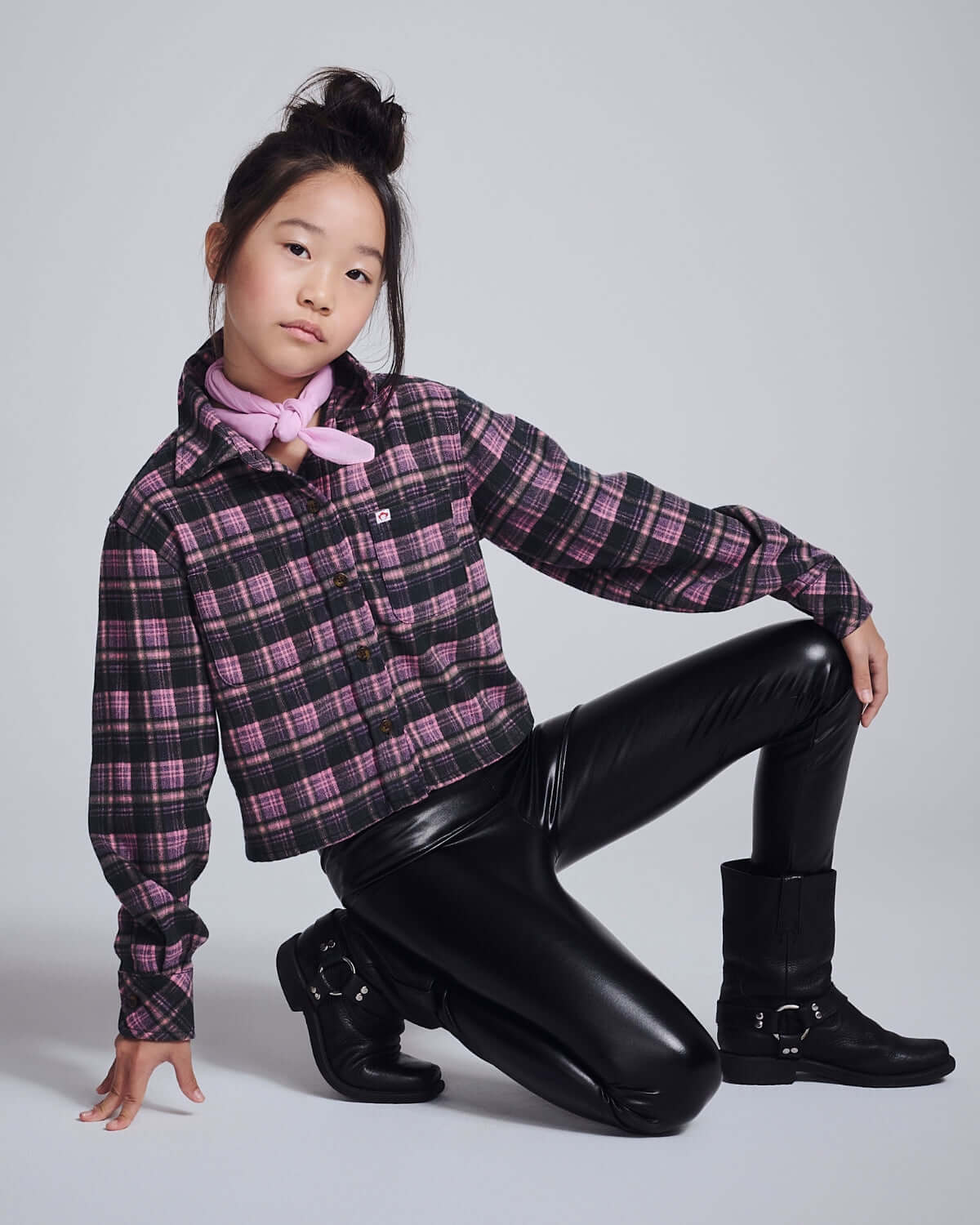 Active girl in trendy Black Shine Leggings, styled with a plaid shirt and pink bandana for a sporty look.