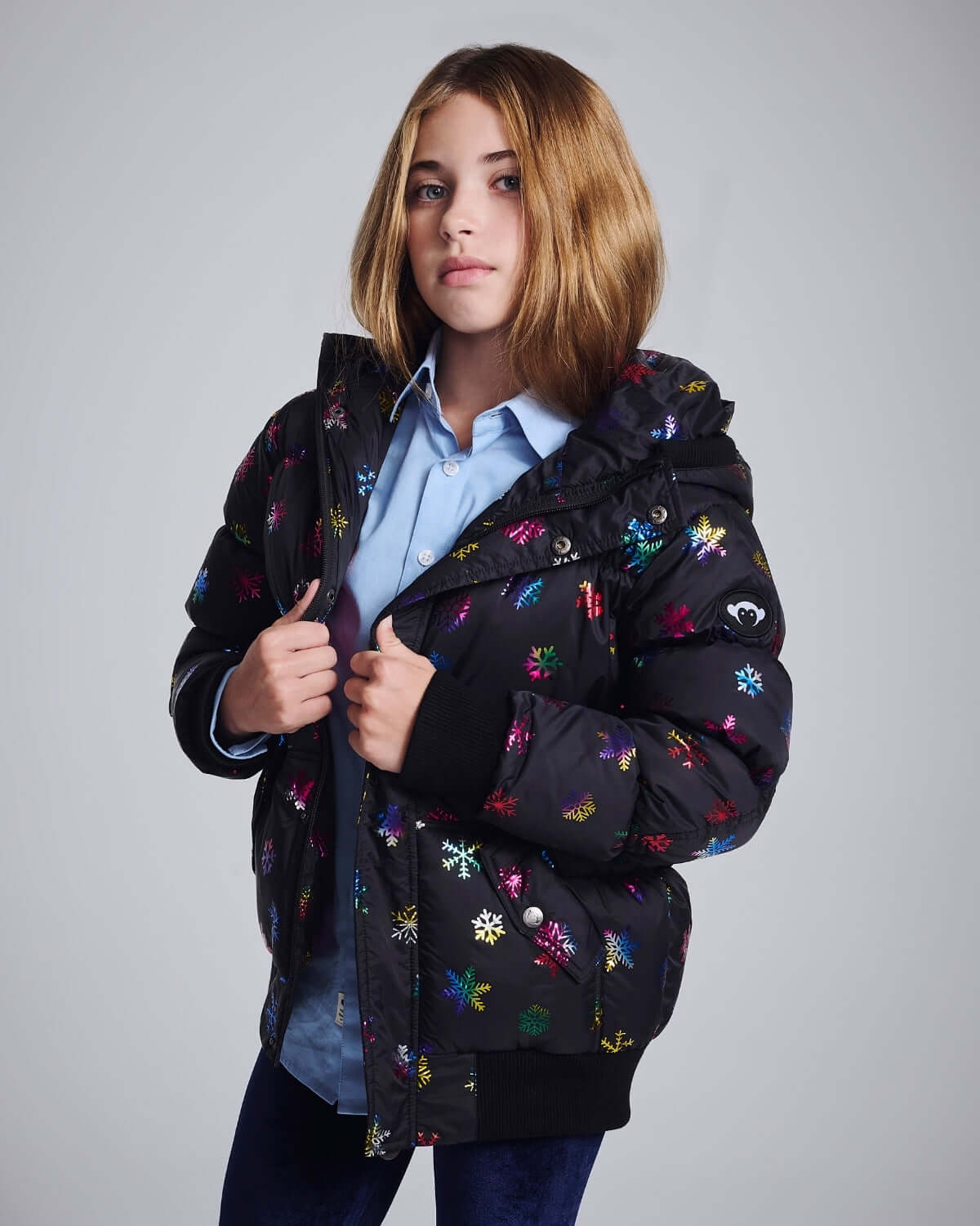 Rainbow Snowflakes Slim Puffy Coat worn by a model, showcasing colorful snowflake design and cozy hood.