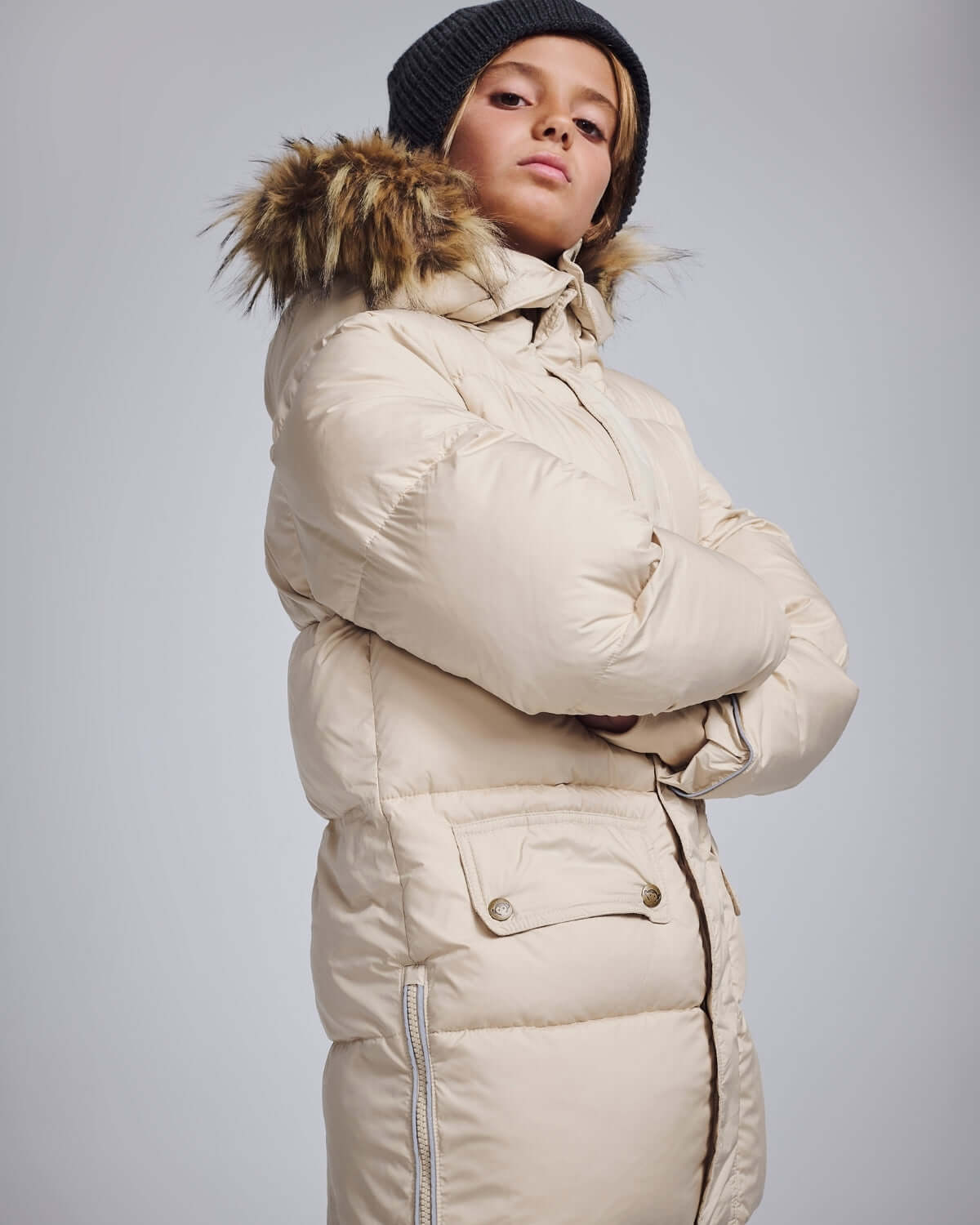 Ivory Expedition Puffer Coat worn by a model with a faux fur hood trim against a neutral background.