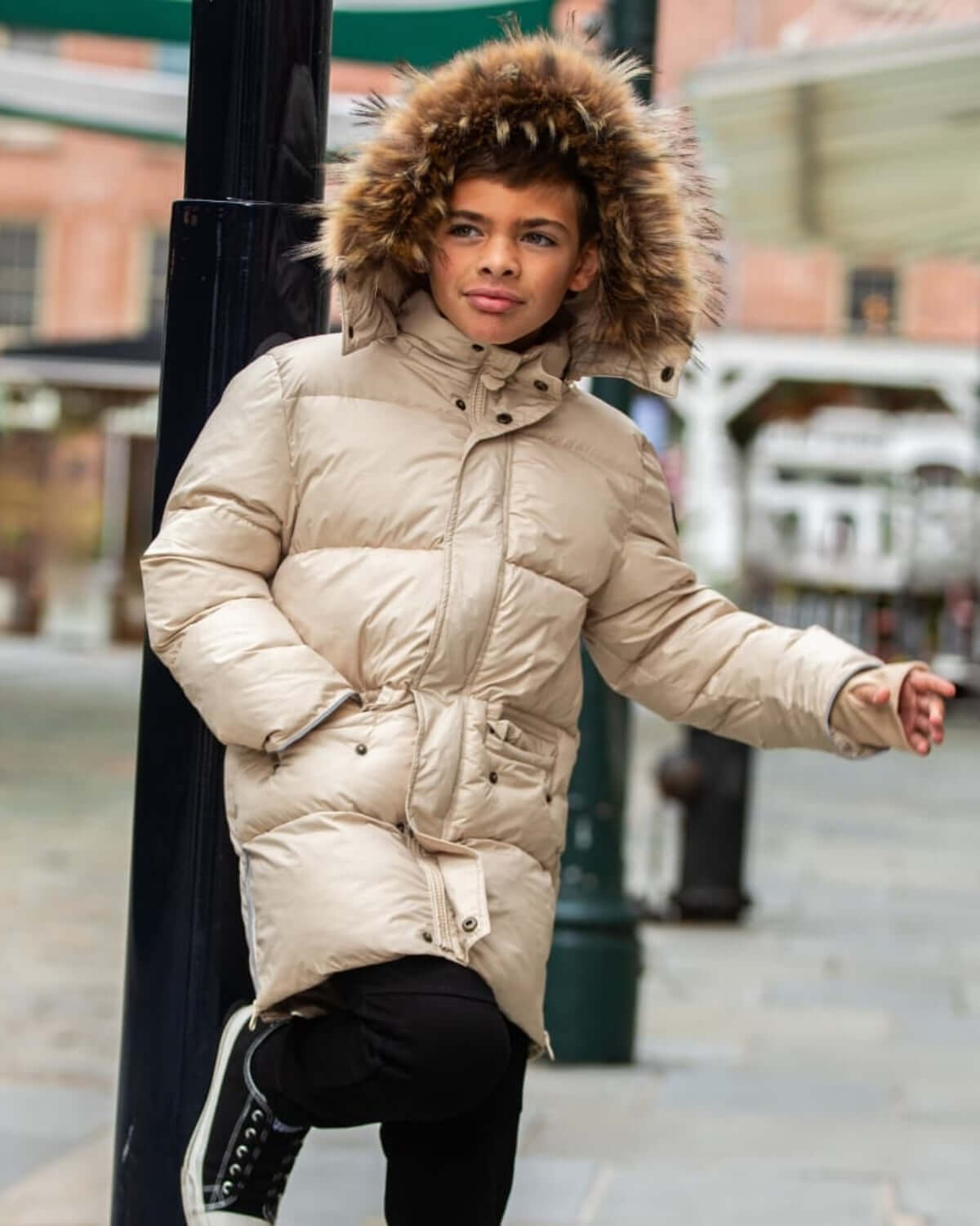 Boy wearing an Ivory Expedition Puffer Coat with a faux fur hood trim, perfect for cold weather adventures.