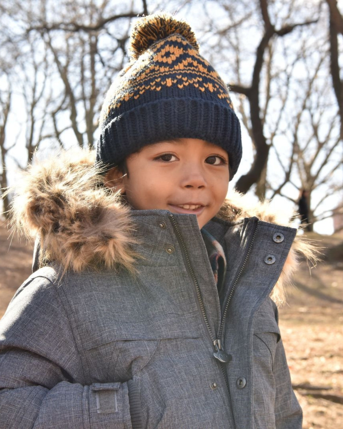 Stylish kid in a cozy navy blue bush hat and warm jacket, ready for winter fun! Perfect for trendy kids' clothes.