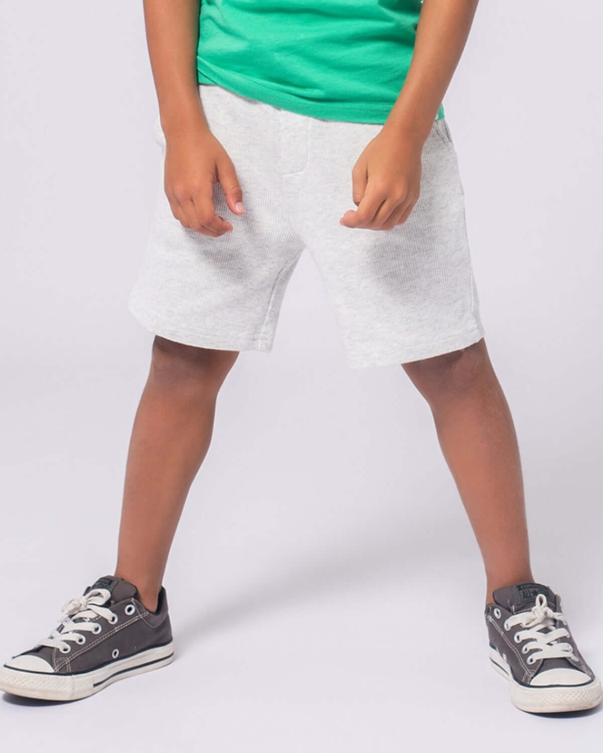 Stylish boy in Cloud Heather Resort Shorts ready for adventure, paired with a vibrant green tee and cool sneakers.