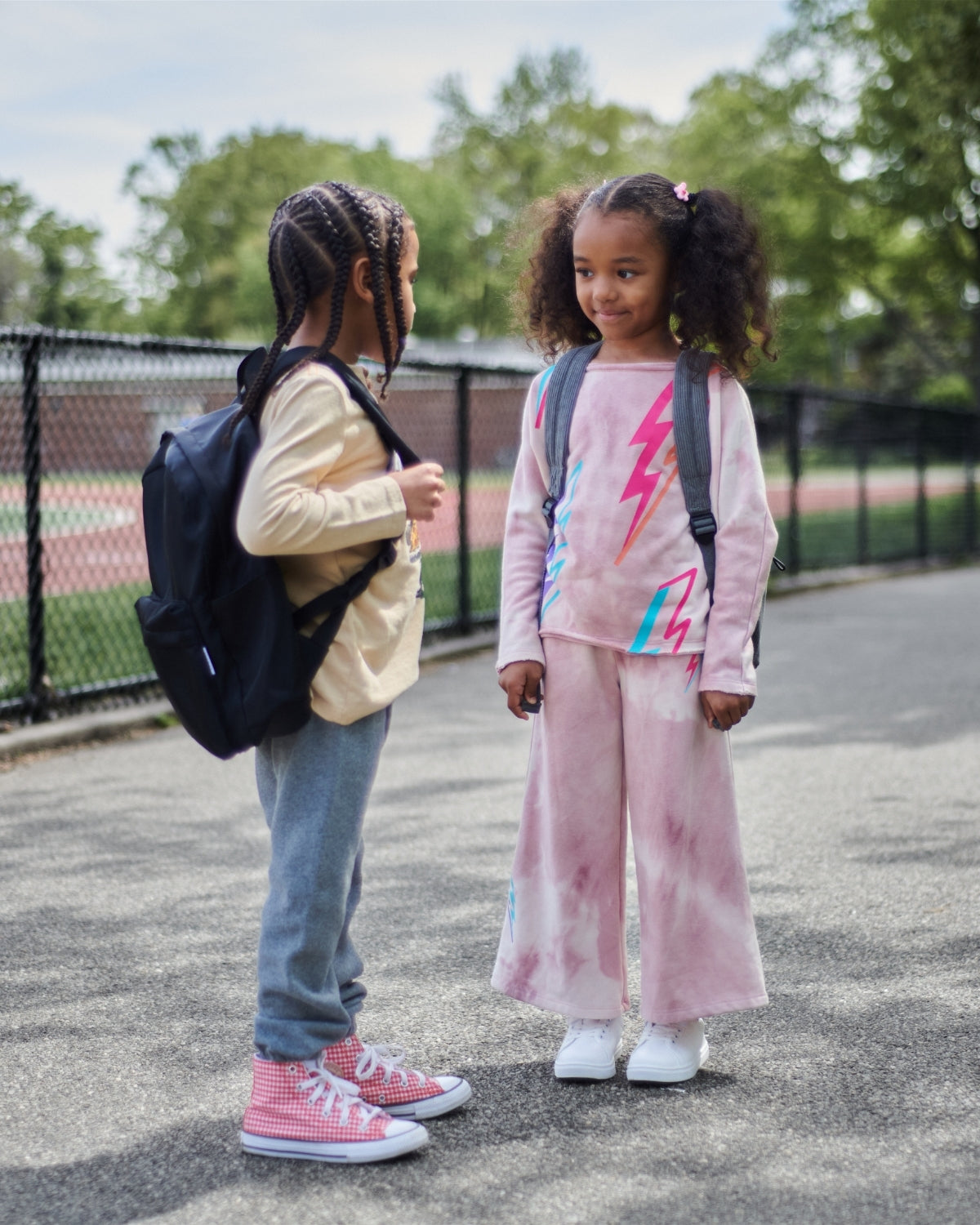 Two stylish kids in playful outfits, ready for a fun day at school with backpacks on—where fashion meets comfort!