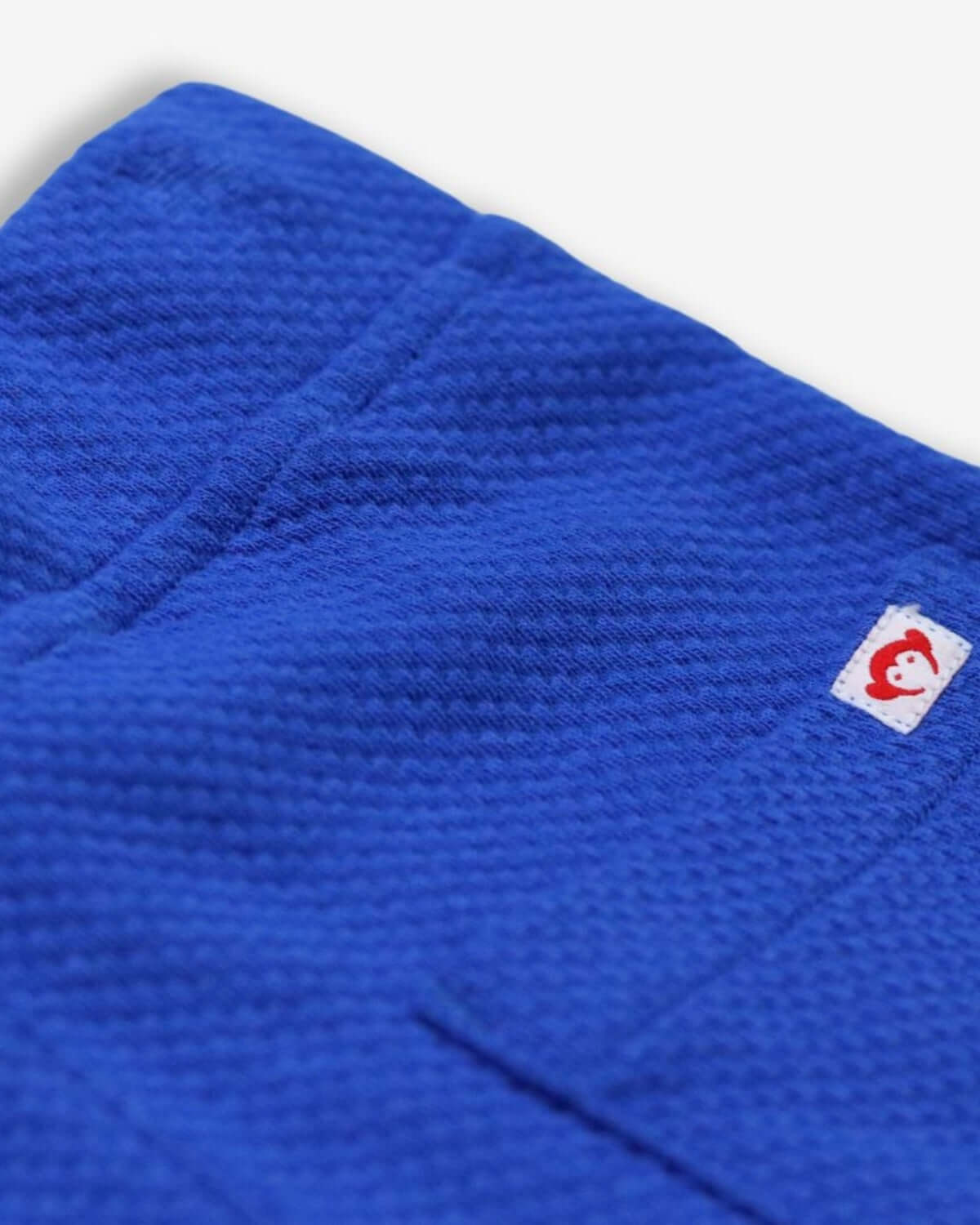 Close-up of the vibrant nautical blue texture of Preston shorts, showcasing high-quality kids clothes for stylish adventures.