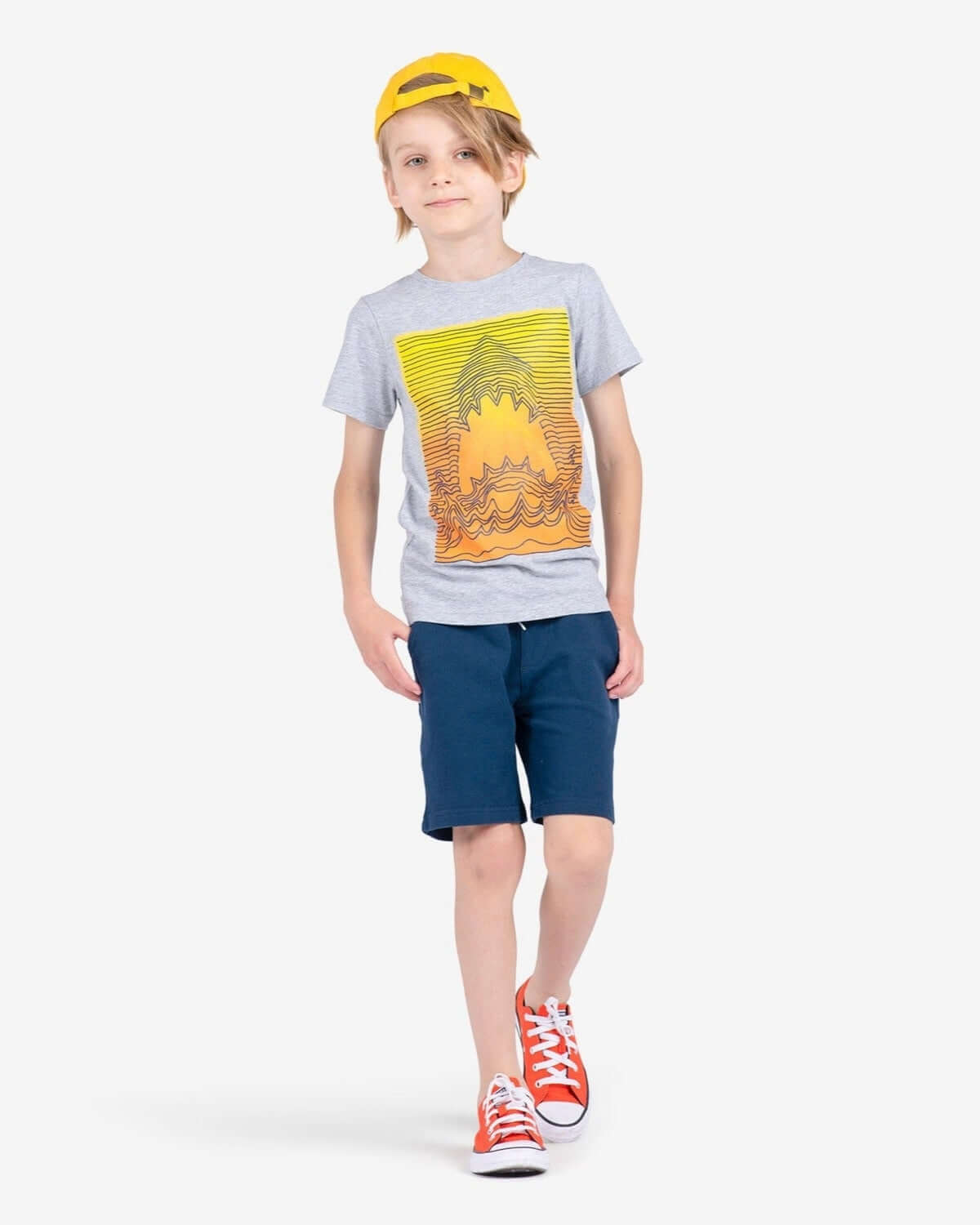 Cool kid strutting in Navy Blue Preston Shorts and a vibrant tee, pairing style with playful vibes for smart summer fun!
