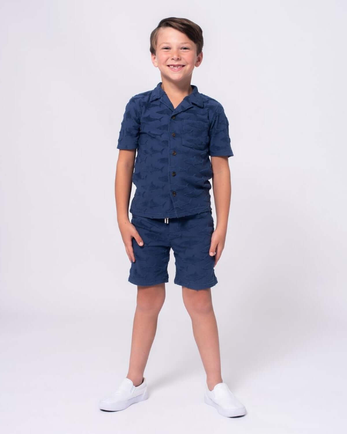 Boy wearing Navy Shark Resort Terry Shorts and matching shirt with shark print, perfect for beach or casual outings.