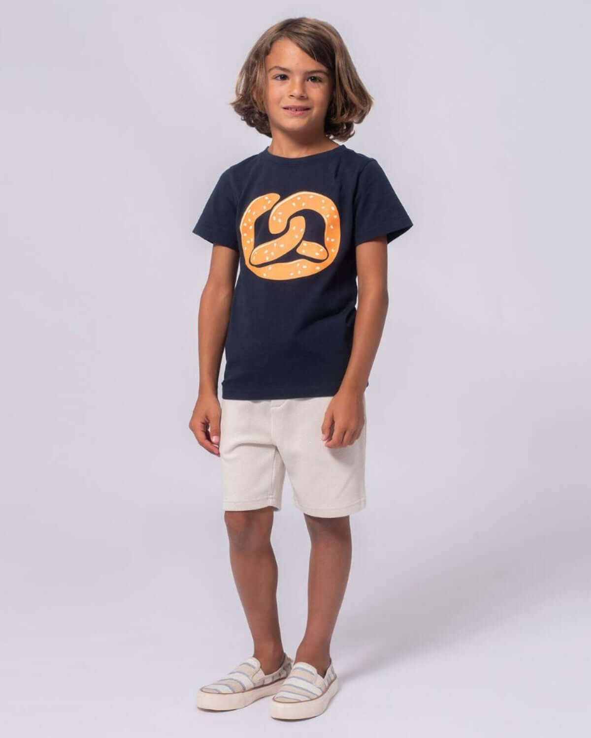 Boy wearing Off White Resort Shorts with navy T-shirt and sandals, perfect for summer adventures.