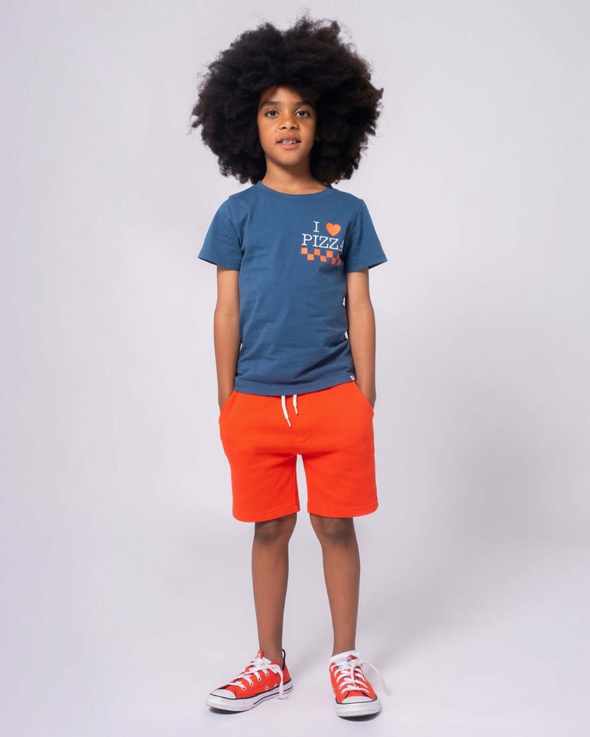 Stylish kid rocking vibrant orange Preston Shorts and a fun pizza tee, perfect for playful adventures and back-to-school vibes!