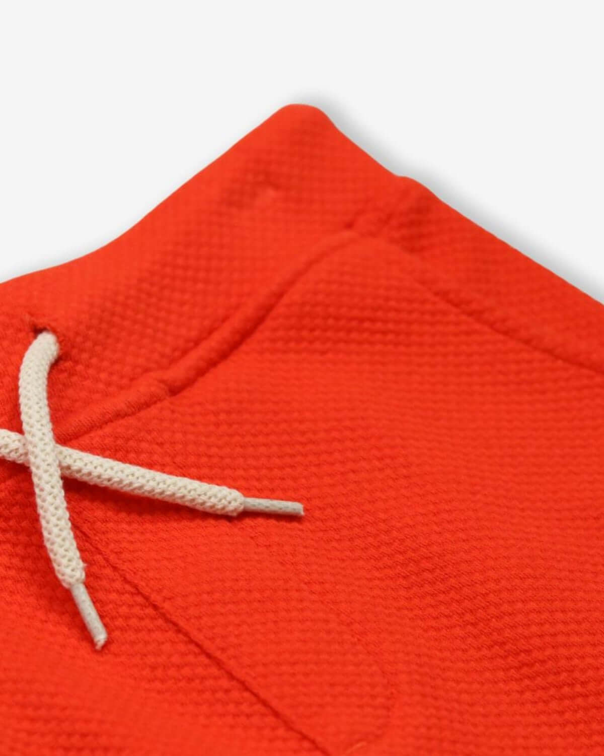 Close-up of vibrant orange Preston Shorts with soft fabric and drawstring, perfect kids clothes for stylish playtime.