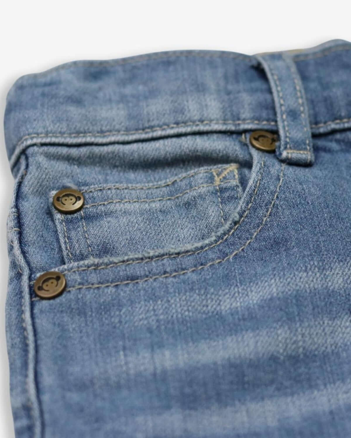 Close-up of playful sun-wash denim shorts showcasing high-quality stitching for adventurous kids' outfits.