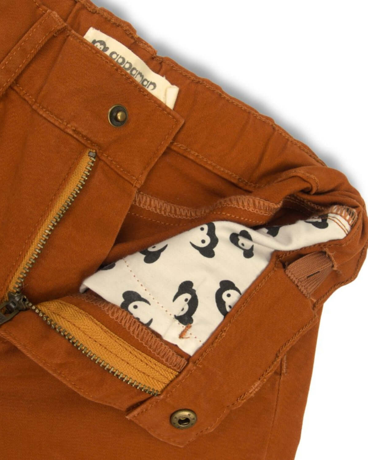 Close-up of Appaman's terracotta skinny twill pants showing fun penguin lining, a stylish choice for back to school kids clothes.