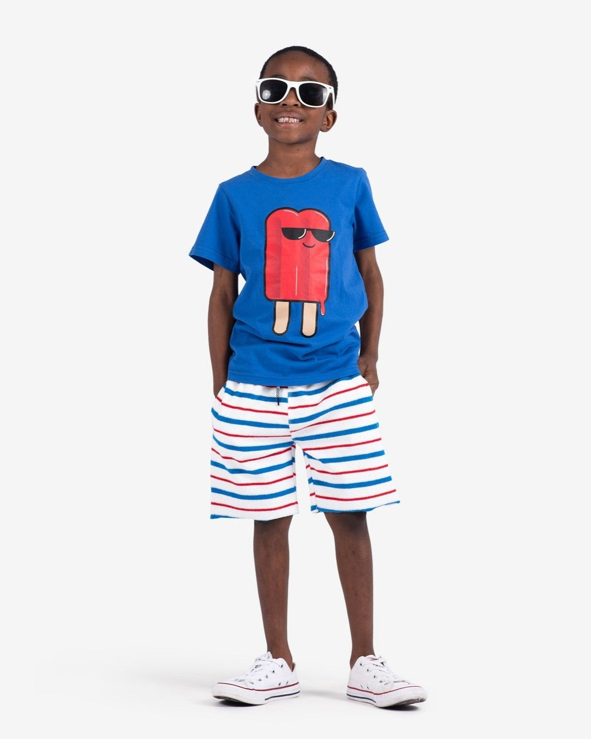 Stylish kid rocking a blue graphic tee and striped red, white, and blue shorts—perfect for fun summer days!