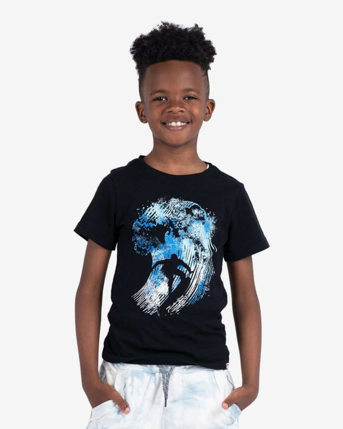 Catching Waves Graphic Tee featuring a boy smiling in a black shirt with a surfer graphic tackling blue waves.