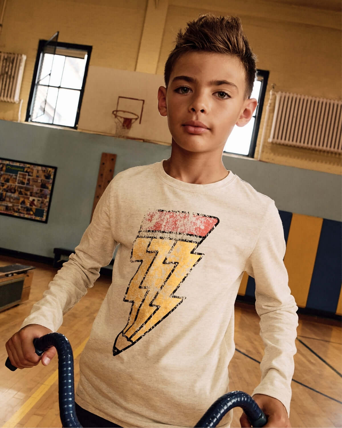 A cool boy in a Cloud Heather Graphic Long Sleeve Tee featuring a lightning bolt pencil, perfect for stylish kids on the go!