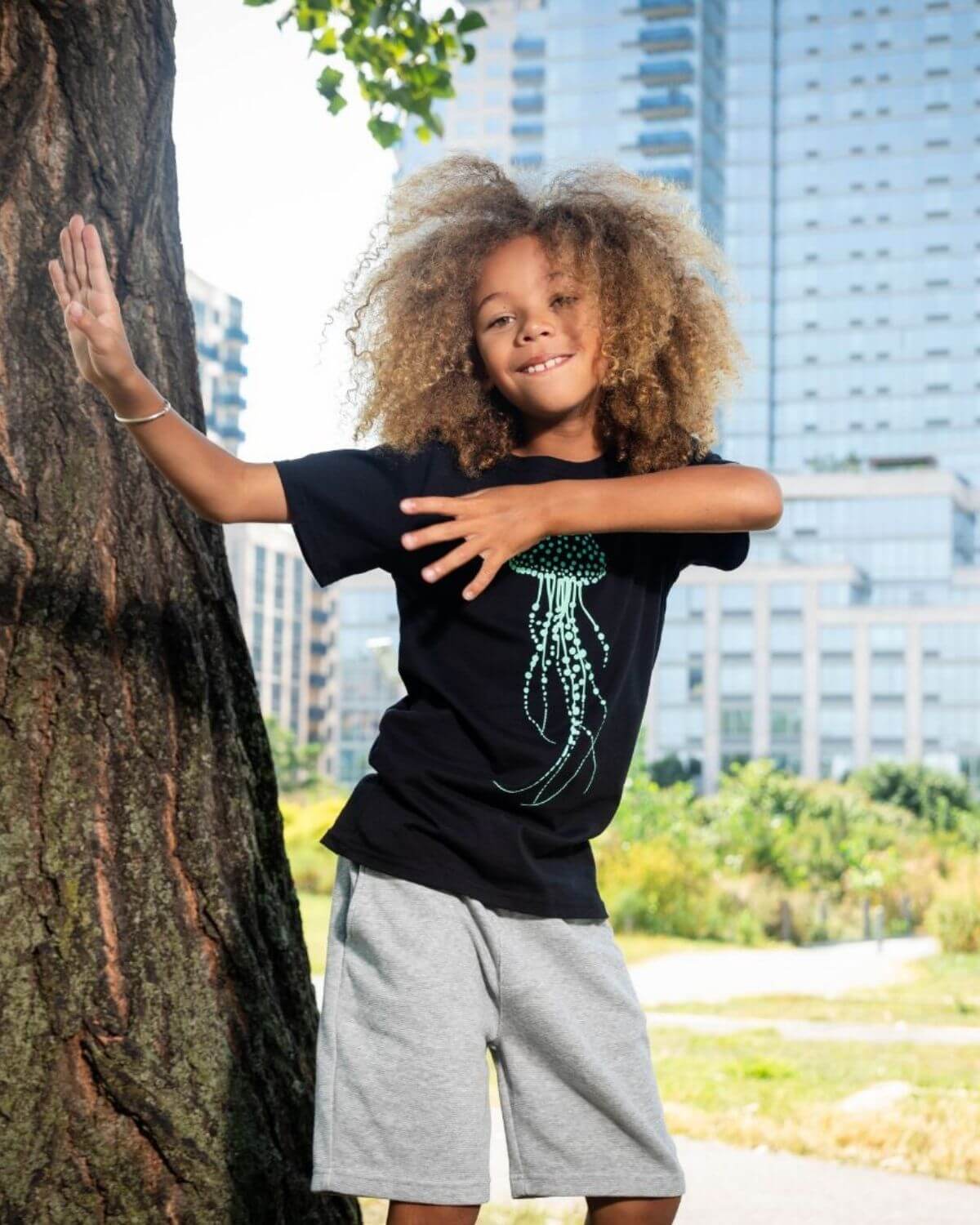 Stylish boy in a jellyfish tee and shorts, ready for fun adventures in vibrant kids clothes.