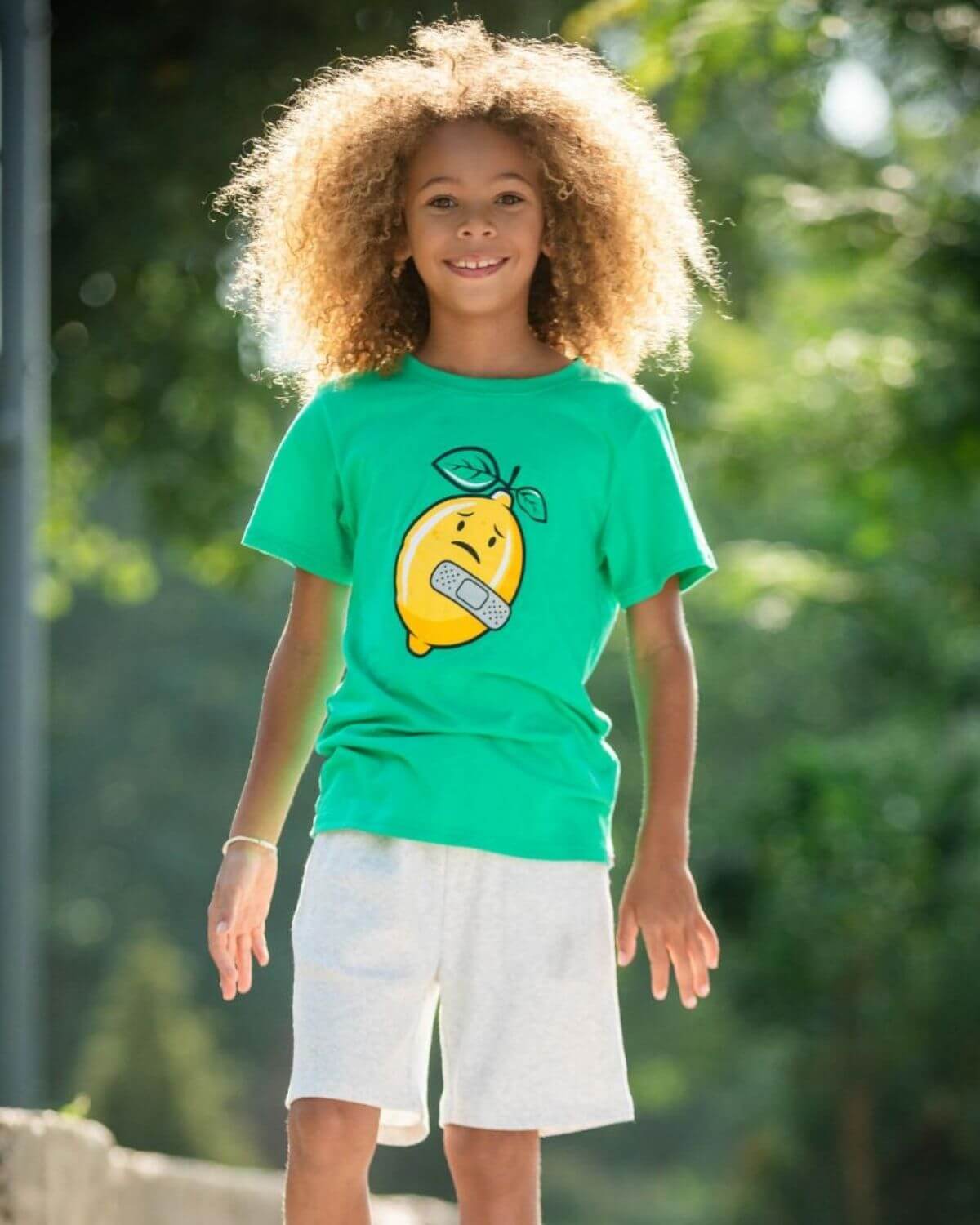 Playful boy in a green Lemon Aid tee with Lenny the Lemon, perfect for stylish kids clothes, high quality back to school wear.