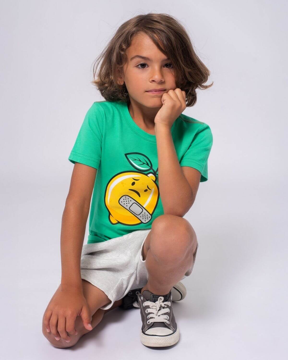 Stylish kid in a lemon graphic tee, showcasing playful design—perfect for back-to-school fun in high-quality kids clothes.