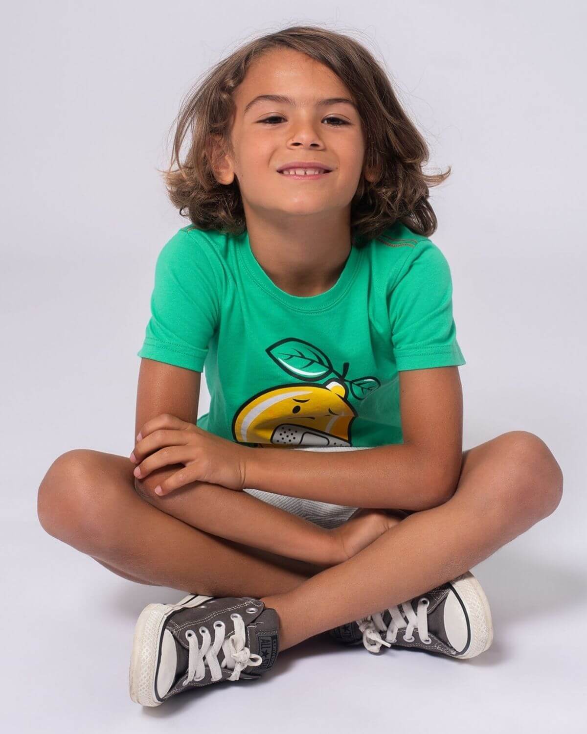 Stylish boy in green Lemon Aid tee, showcasing playful Lenny the Lemon—perfect for back to school fun in high-quality kids' clothes!