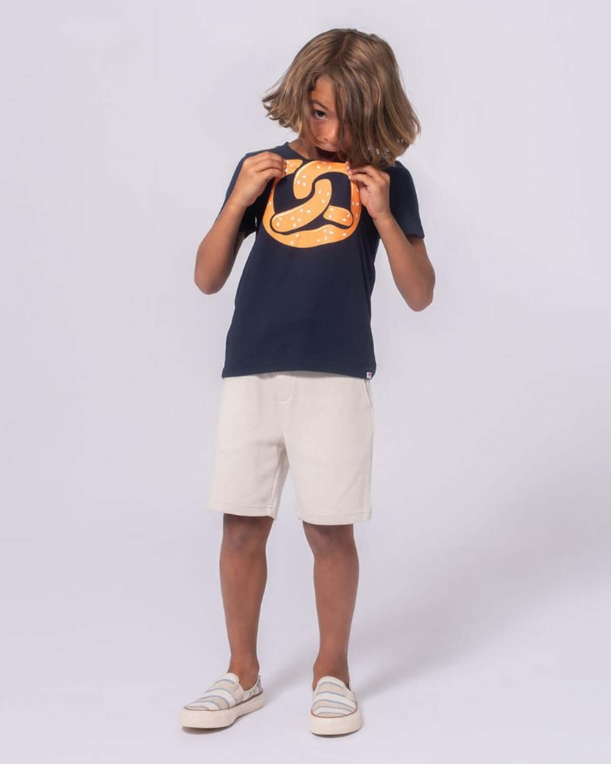 Cool kid rocking a pretzel graphic tee, perfect for playtime or school! Stylish and comfy boys clothing for back to school.
