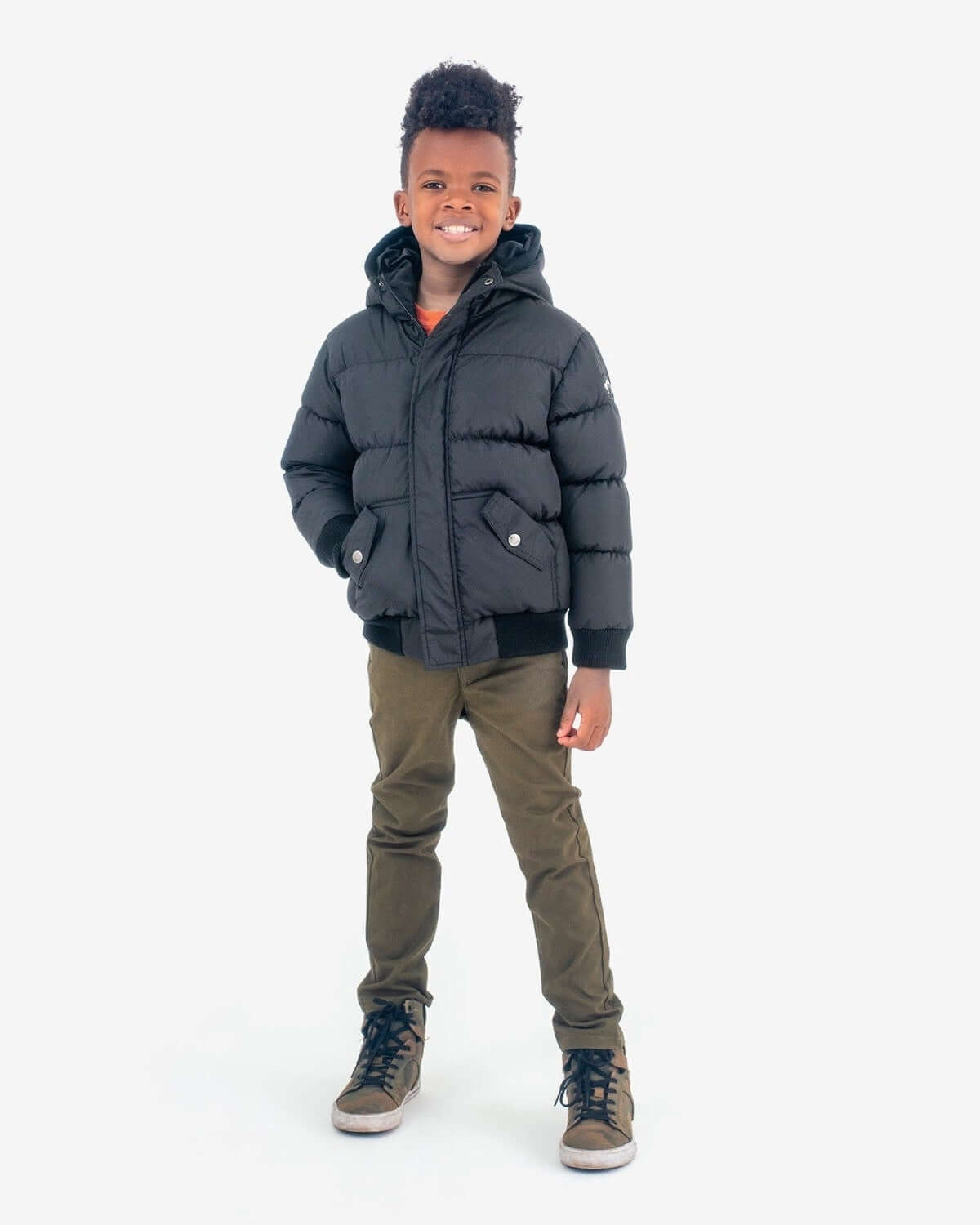 Stylish kid in a cozy black puffy coat, perfect for school and winter adventures. High-quality kids clothes for cool weather fun!