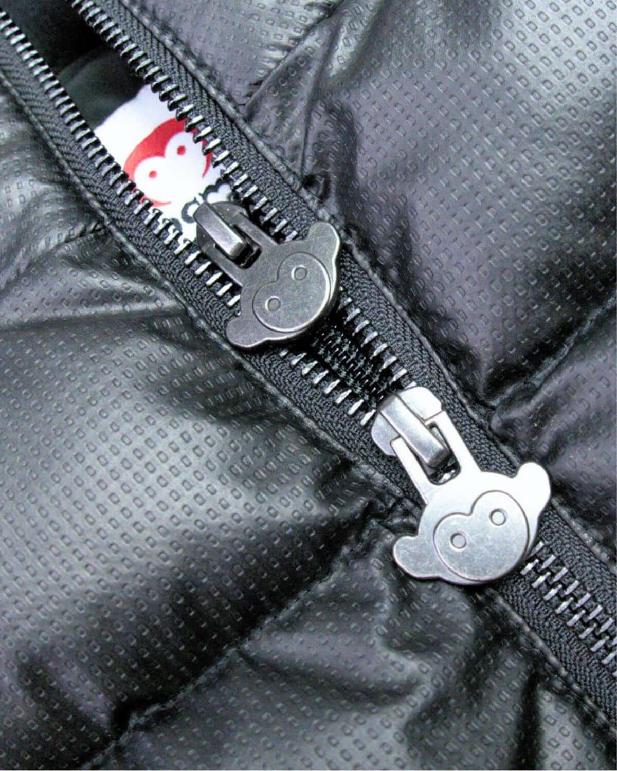 Close-up of playful double zippers on the Black Turnstile Jacket, adding fun detail to kids' high-quality winter wear.