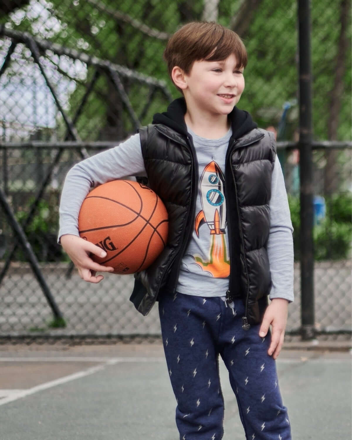 Cool kid in a black Turnstile Jacket, ready to shoot hoops and show off his style! Perfect kids clothes for back to school.