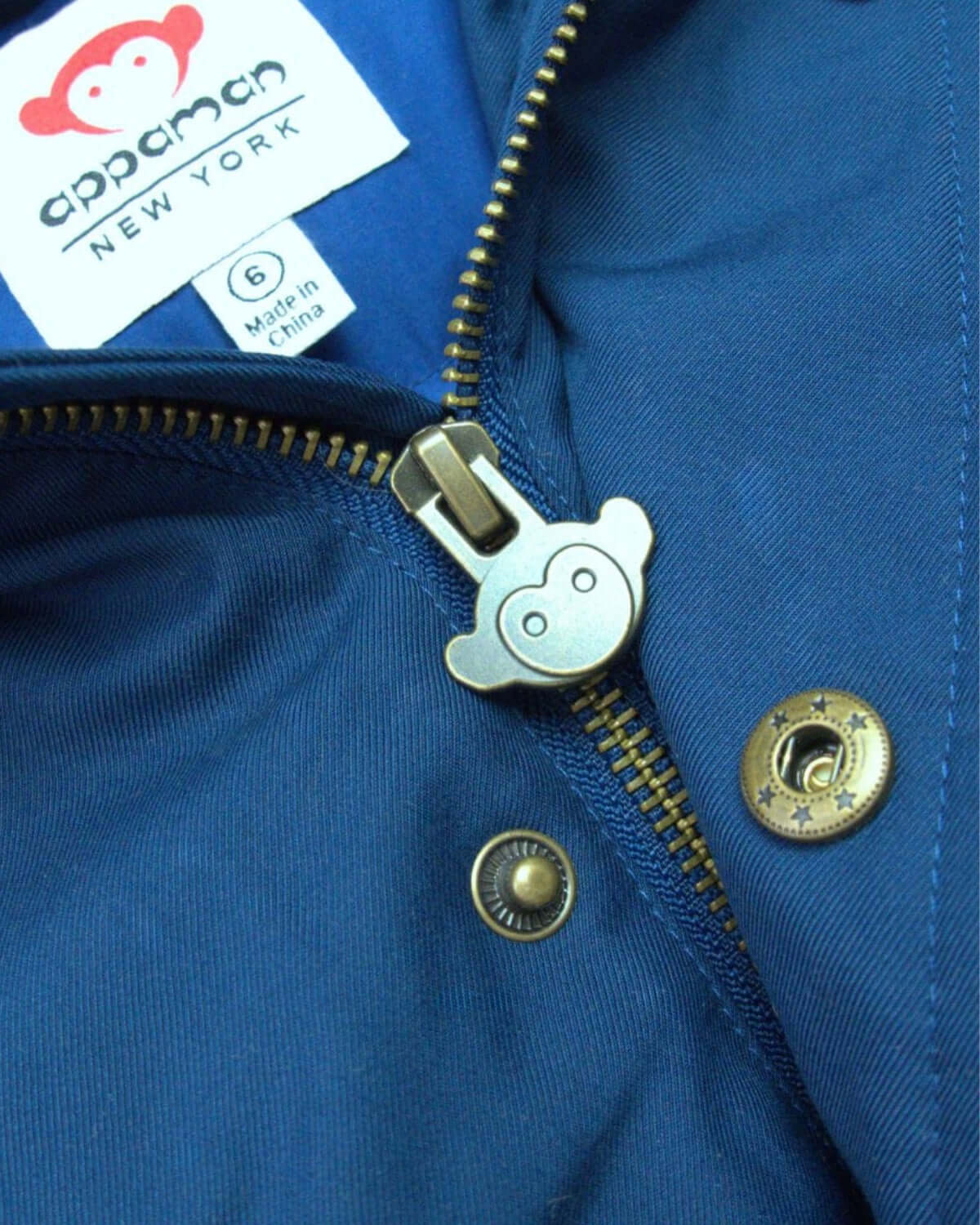 Close-up of Appaman's classic blue City Transit Coat zipper, showcasing stylish design and quality craftsmanship for kids.