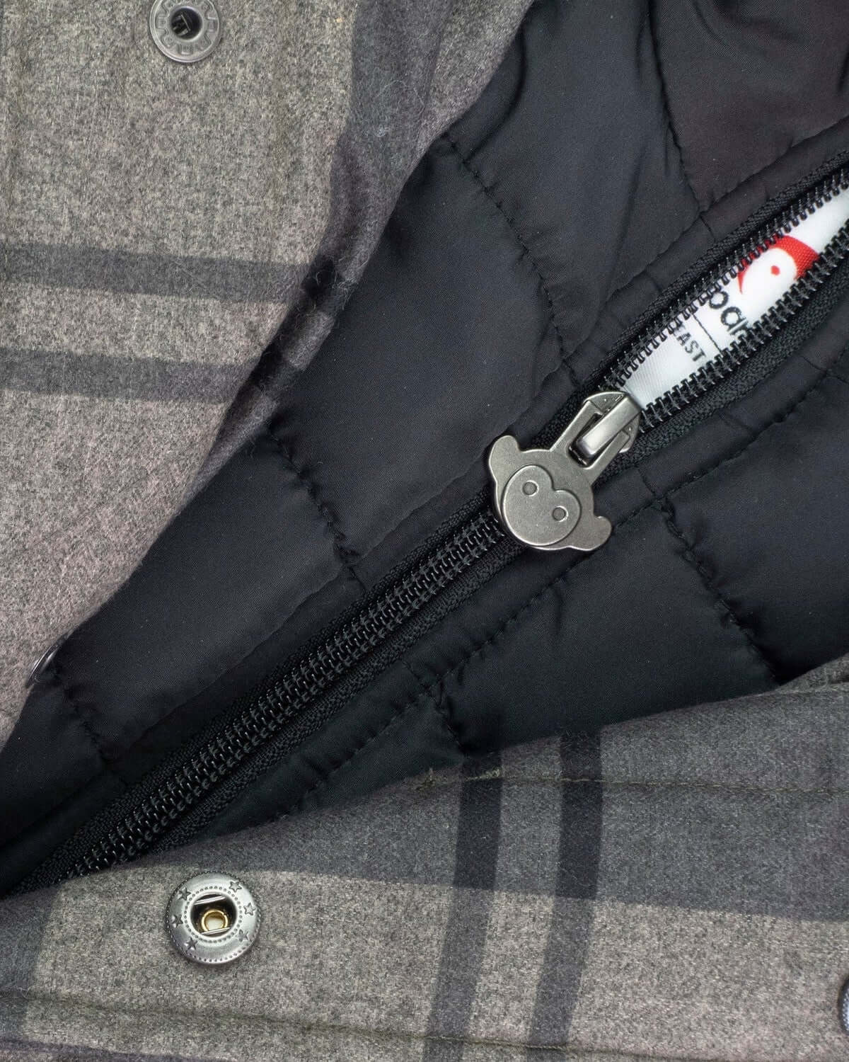 Close-up view of the inner zipper of the Grey Plaid New Gotham Coat showcasing its warm lining.