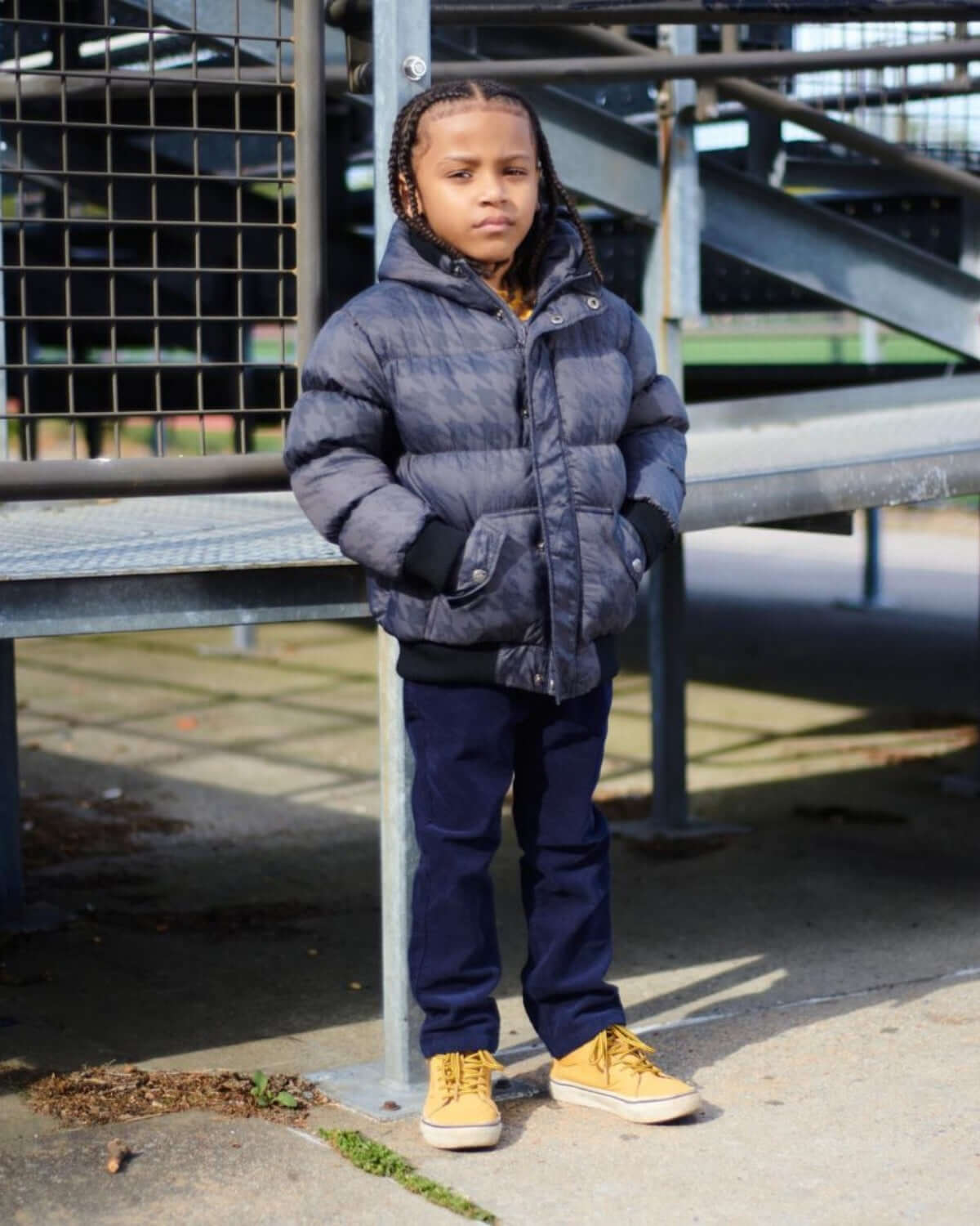 Stylish kid in navy puffy coat embodying warmth and comfort, ready for winter adventures. Trendy high-quality kids clothes!