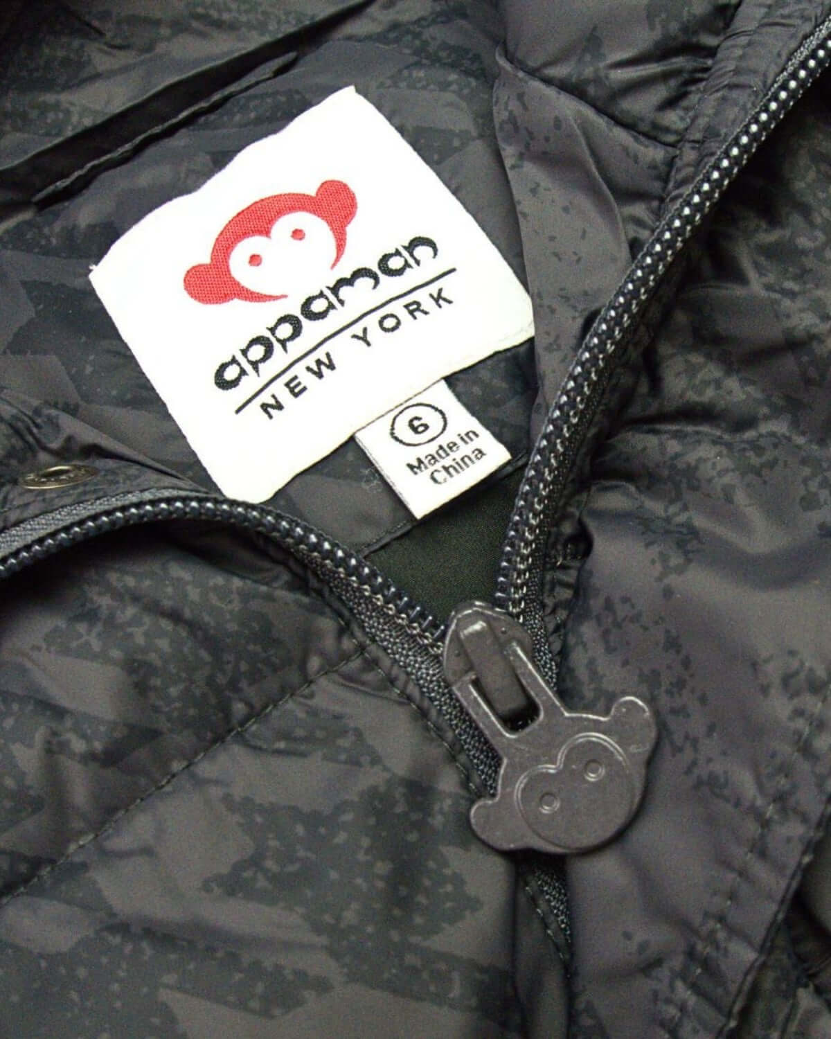 Inside view of Appaman's stylish puffy coat, featuring fun monkey detailing and durable, quality craftsmanship for kids.