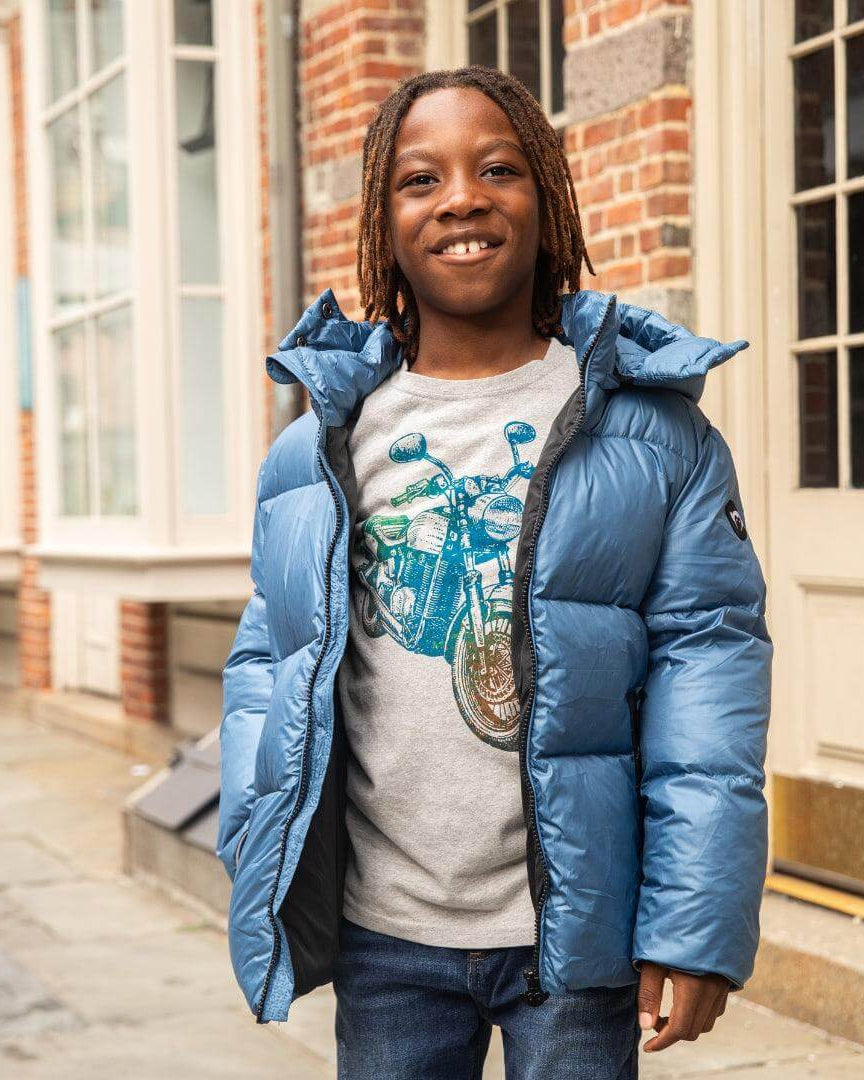 A stylish boy in a light blue mixed puffer coat smiles confidently, ready for fun city adventures or chilly days back to school.