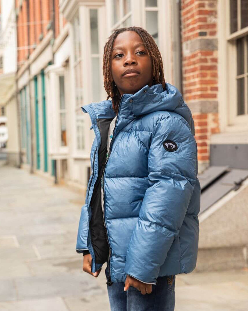 Stylish kid in a light blue mixed puffer coat, ready for city adventures or snowy slopes—perfect for back to school!