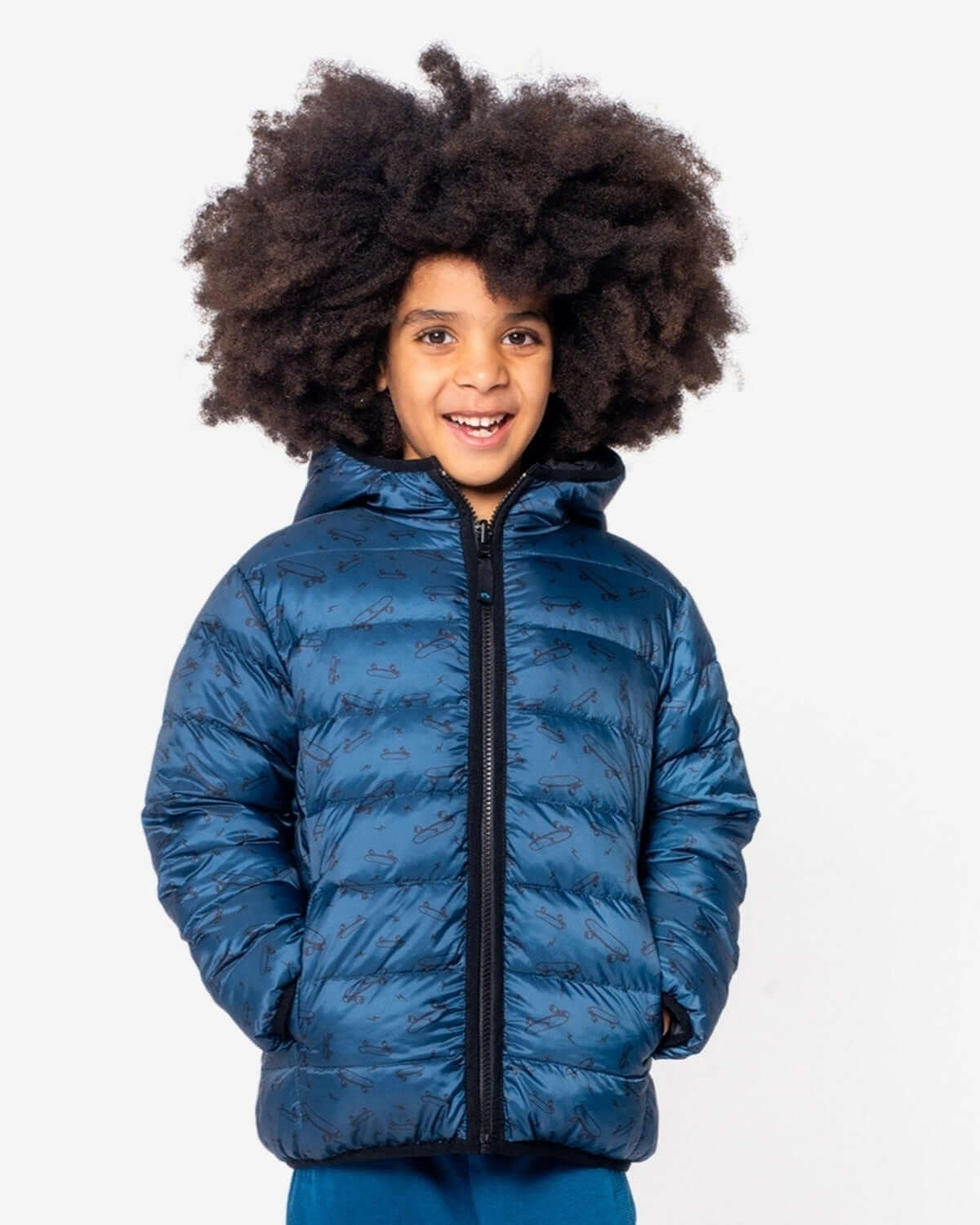 Smiling kid in a stylish blue reversible puffer jacket, showcasing warm winter vibes and ready for adventures!