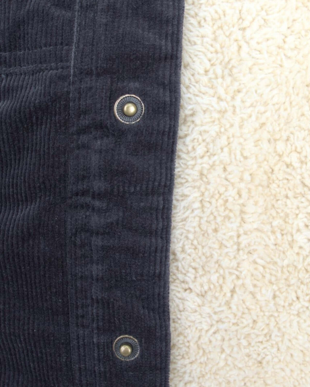 Close-up of the vintage black cord jacket showing soft sherpa lining and stylish snap buttons, perfect for kids' back-to-school fashion.
