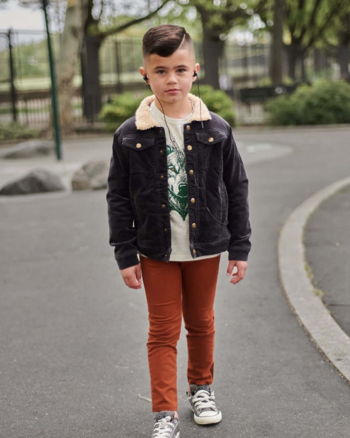 Stylish kid in a vintage black cord jacket with sherpa lining, ready for back to school adventures in high-quality kids clothes.