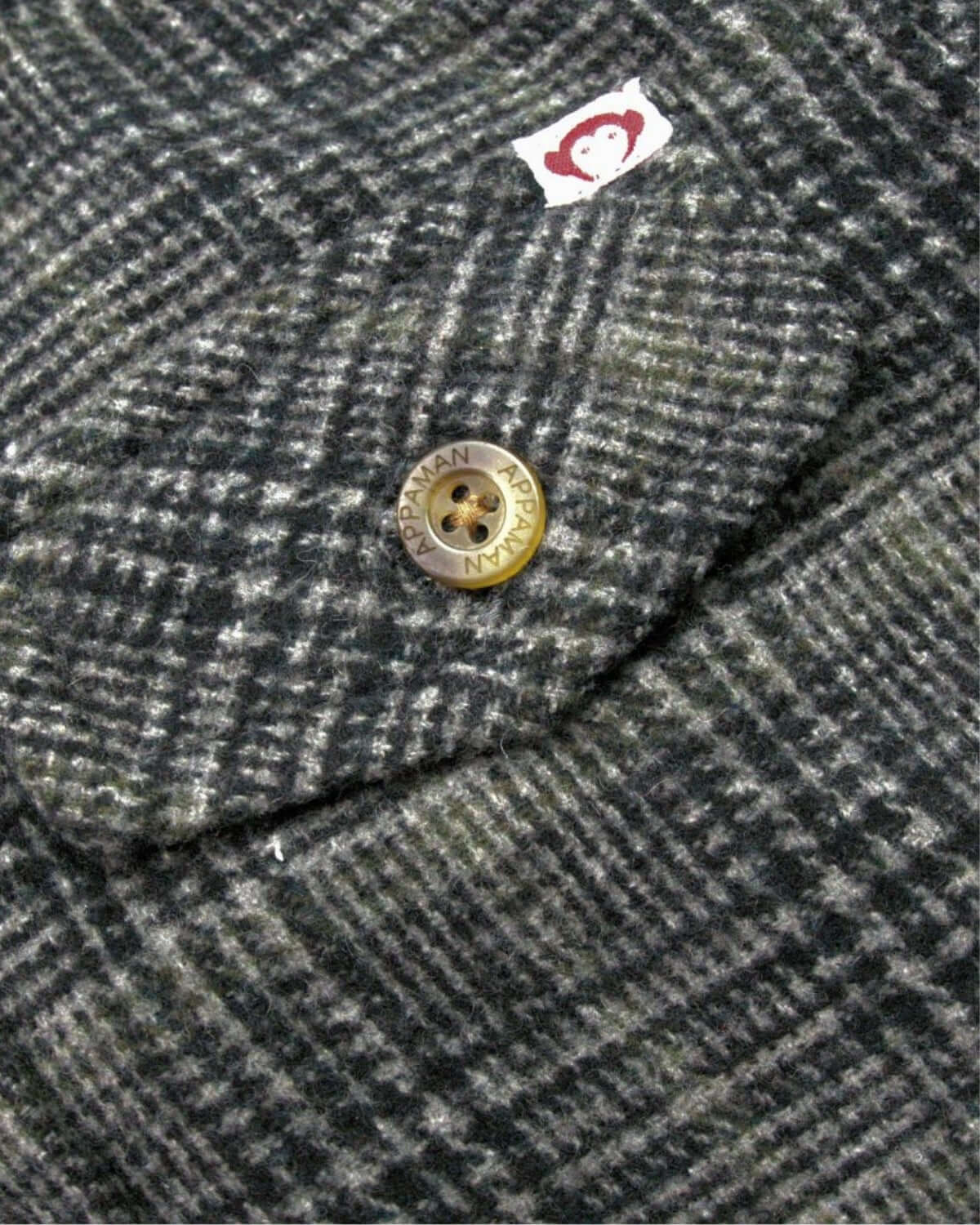 Close-up of the Black/Moss Plaid Glen Hooded Shirt's stylish button and label—fashion-forward kids clothes!