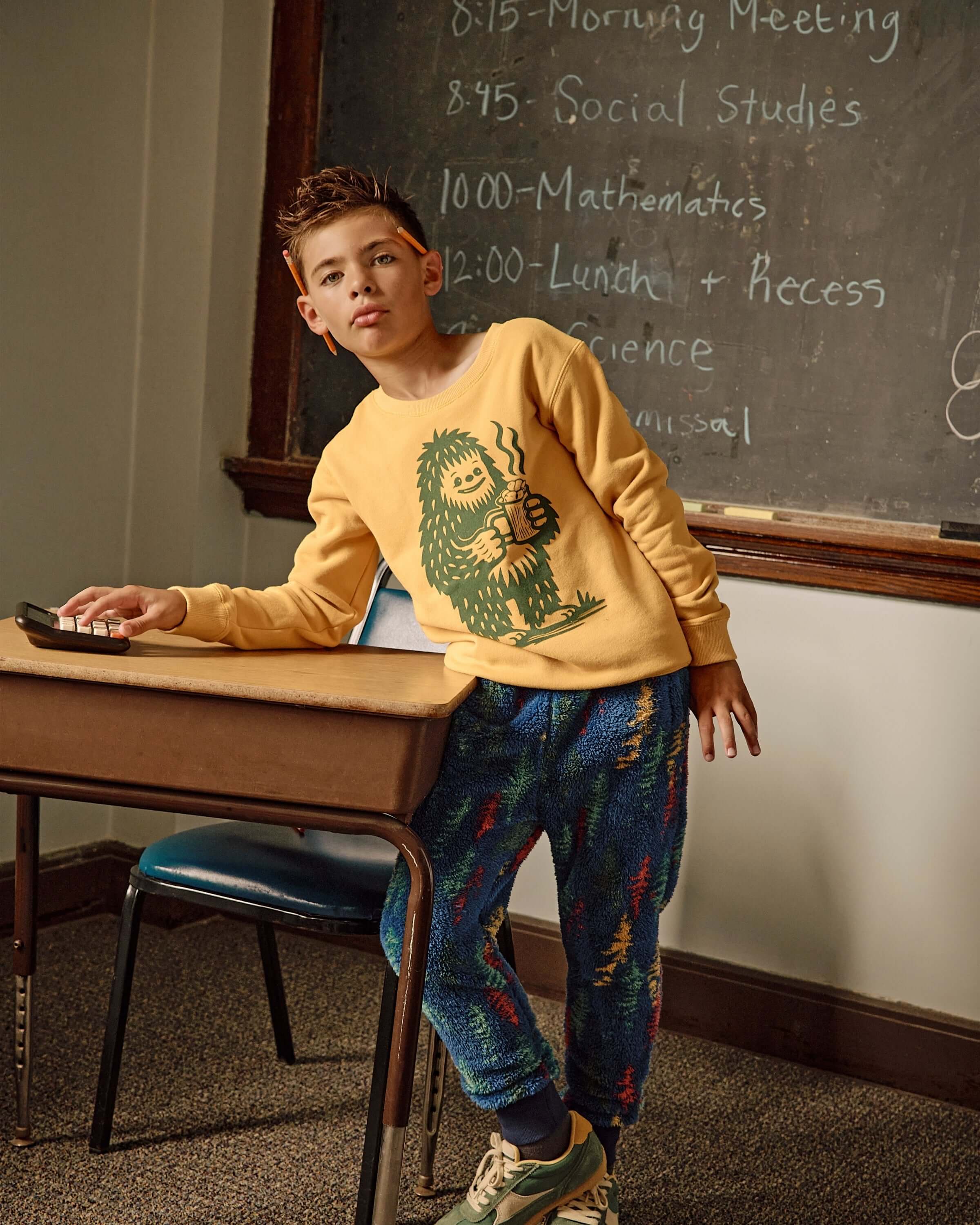 A stylish kid in a mustard Bigfoot crewneck, showcasing fun kids clothes for back to school, comfy and cool!