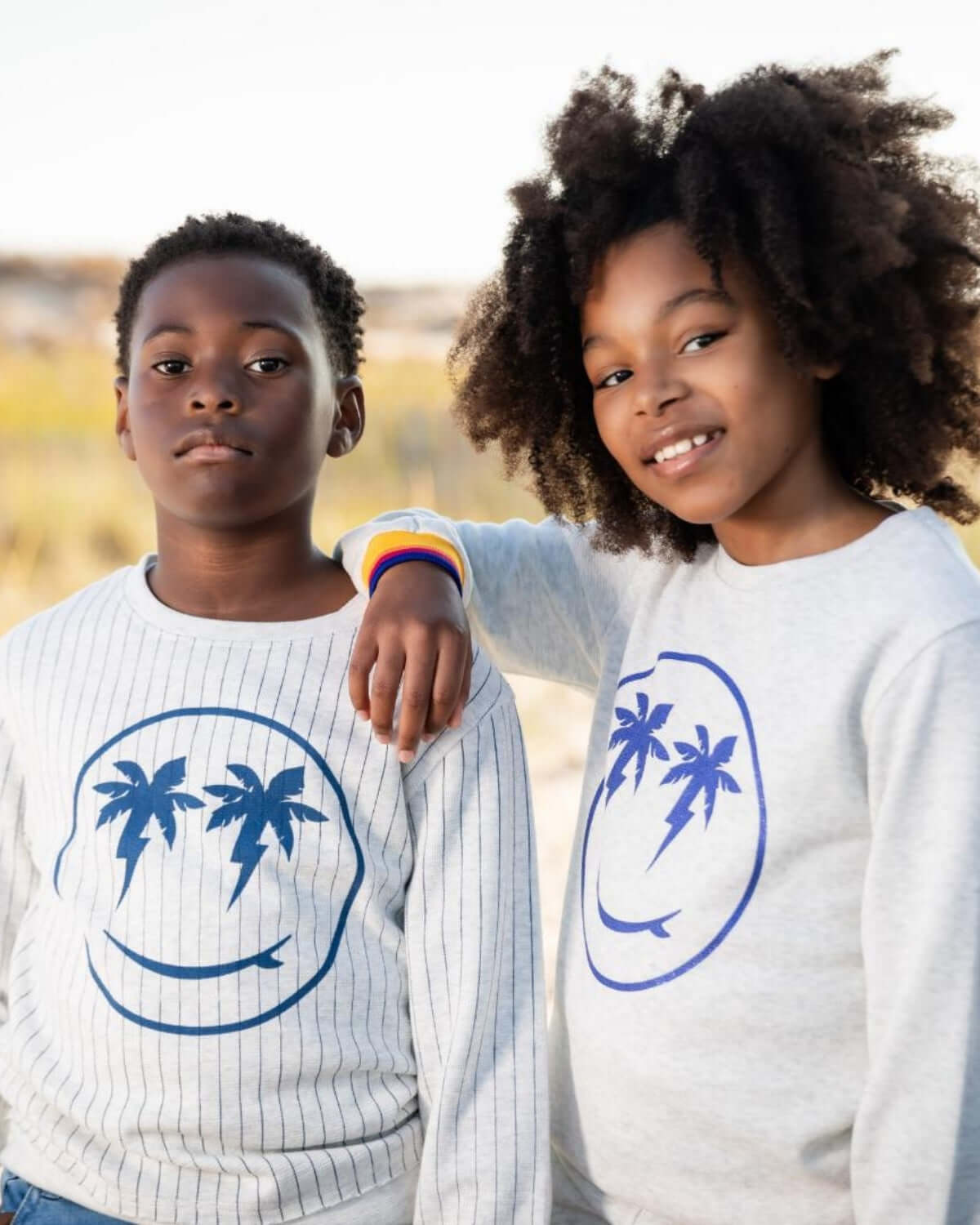 Kids in cozy sweatshirts with playful palm tree designs, perfect for stylish back-to-school adventures.