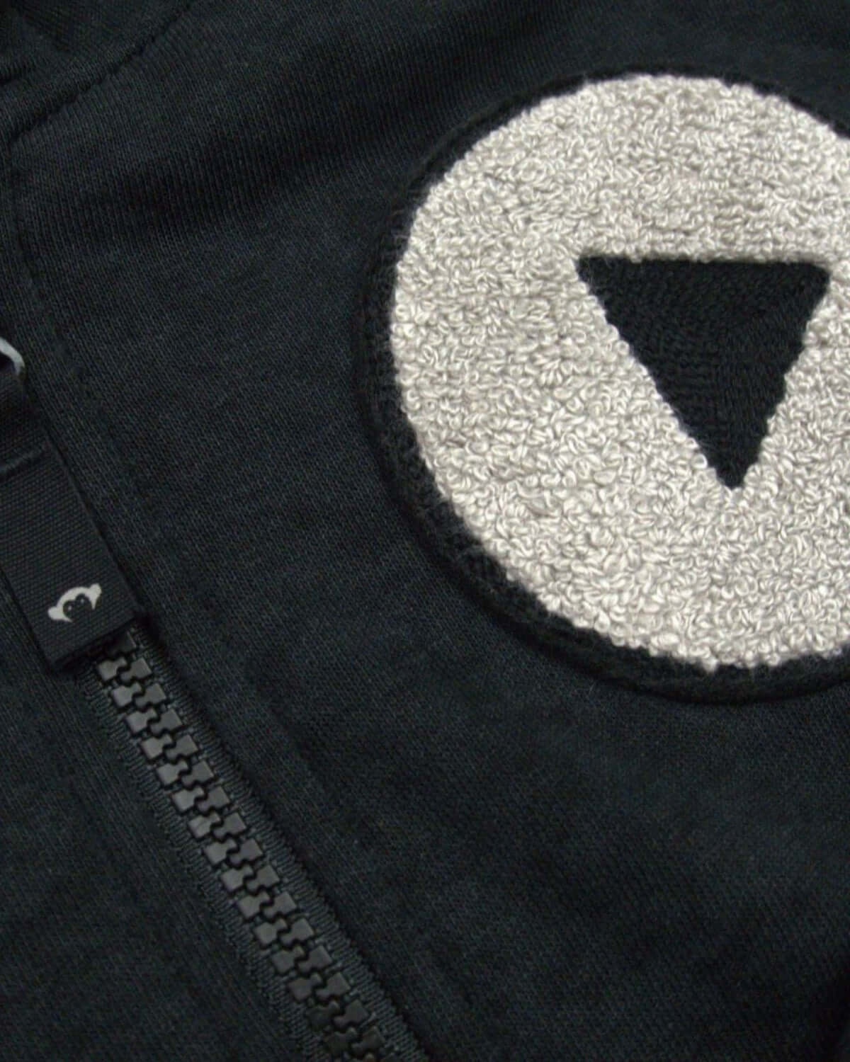 Close-up of the stylish Play Magic Zip Hoodie, featuring a unique triangle patch and QuickFree zipper for trendy kids.