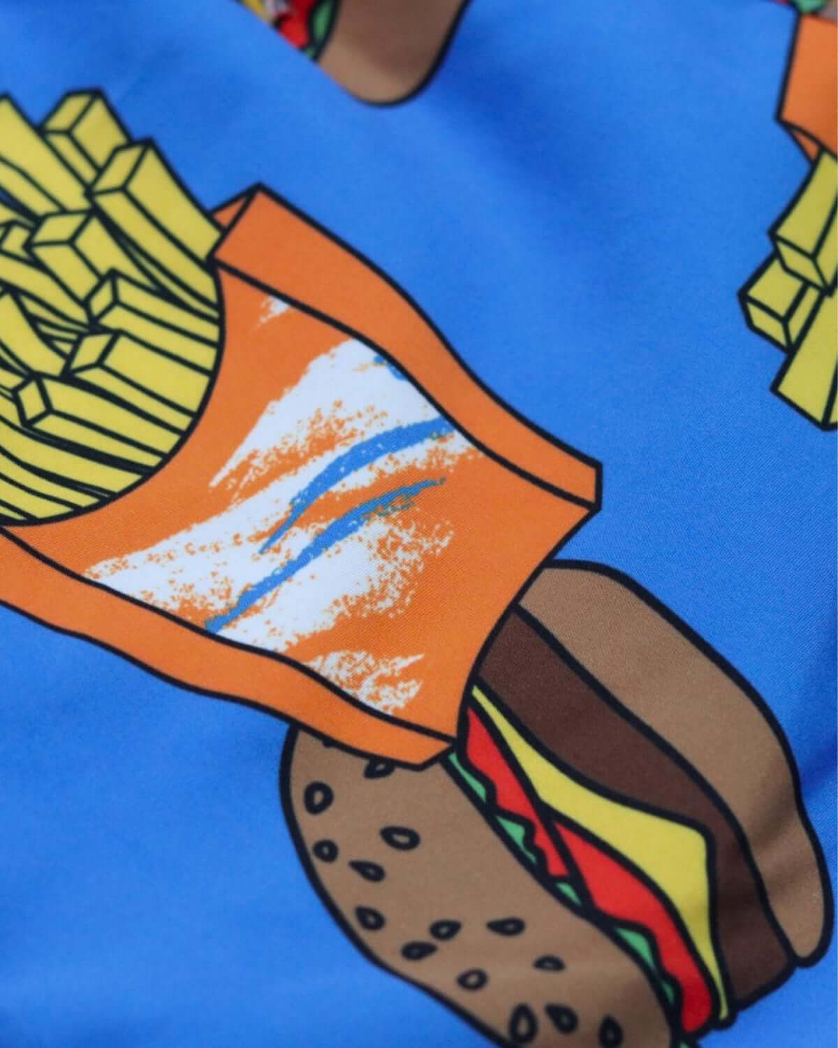 A close-up of playful burgers and fries graphics on vibrant blue fabric, perfect for kids' swim trunks.