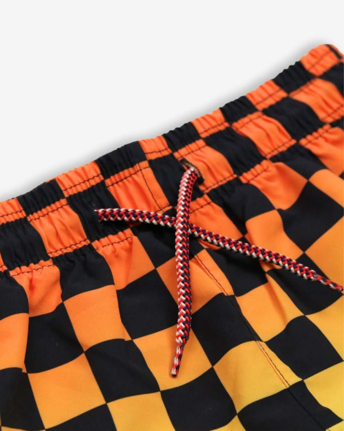 Vibrant orange and black checkerboard pattern on Appaman swim trunks with a stylish drawstring. Ideal for kids' summer fun!