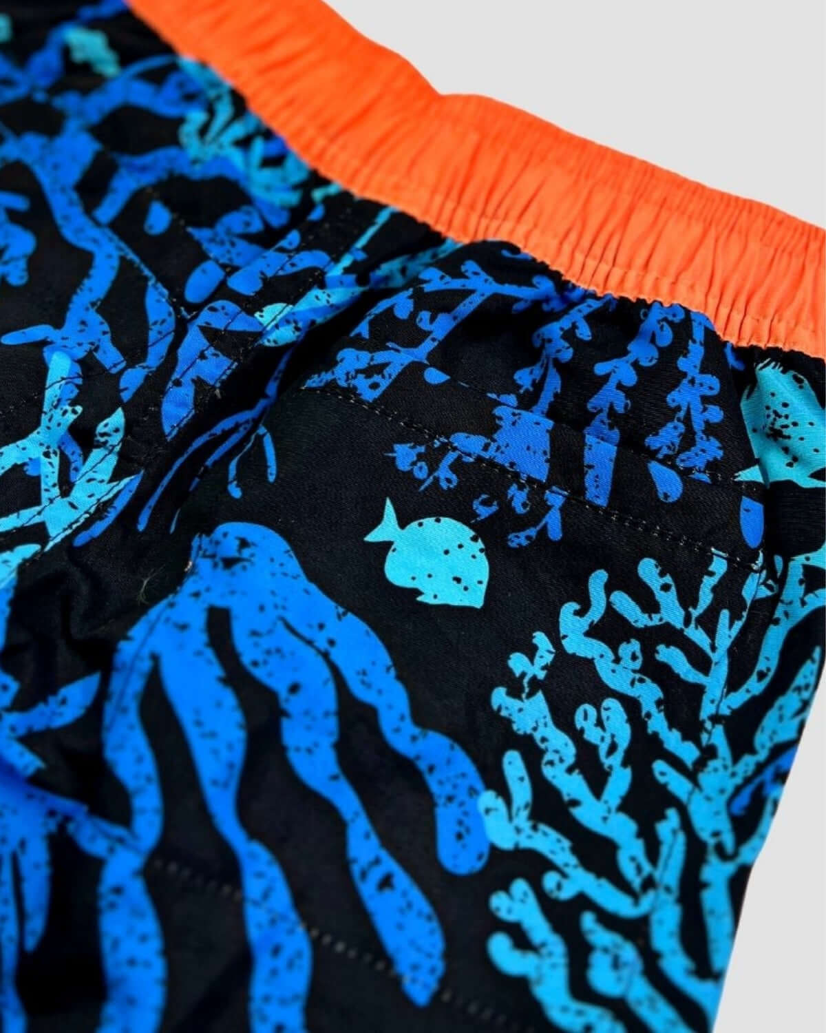 Coral Swim Trunks featuring a colorful underwater pattern with coral and fish design.
