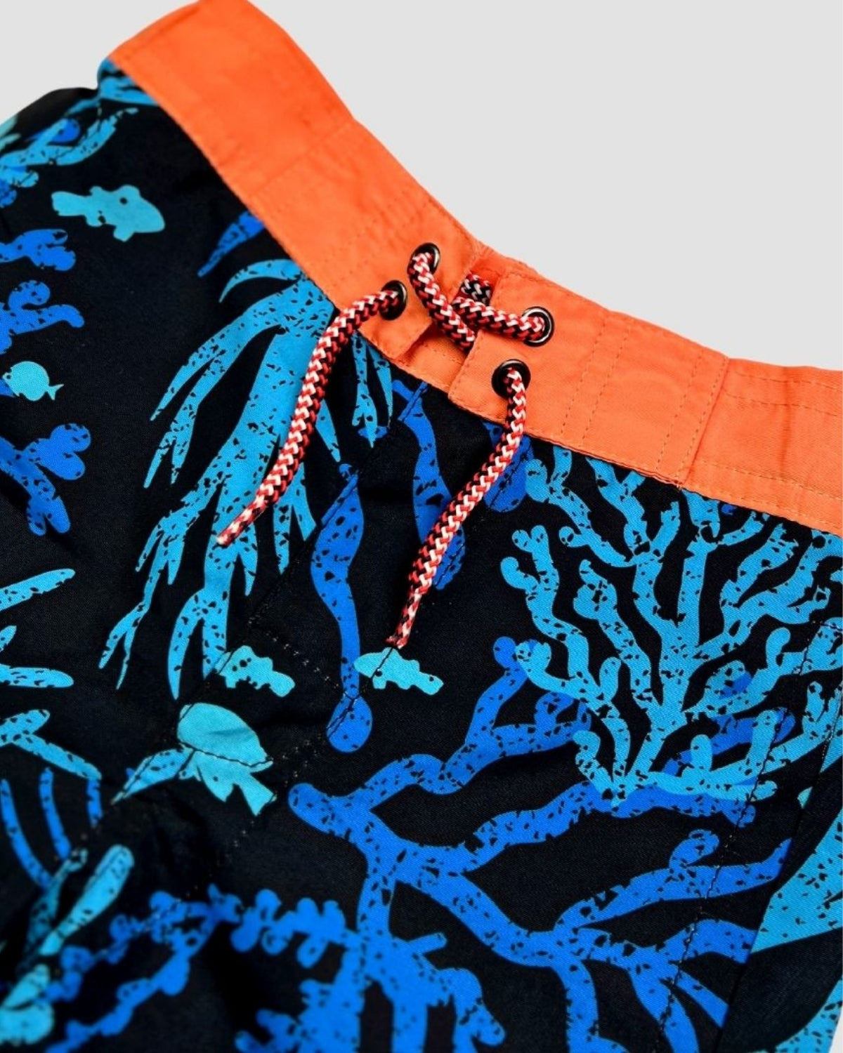 Vibrant coral swim trunks with playful aquatic patterns, ready for beach adventures and poolside fun! Perfect for stylish kids.