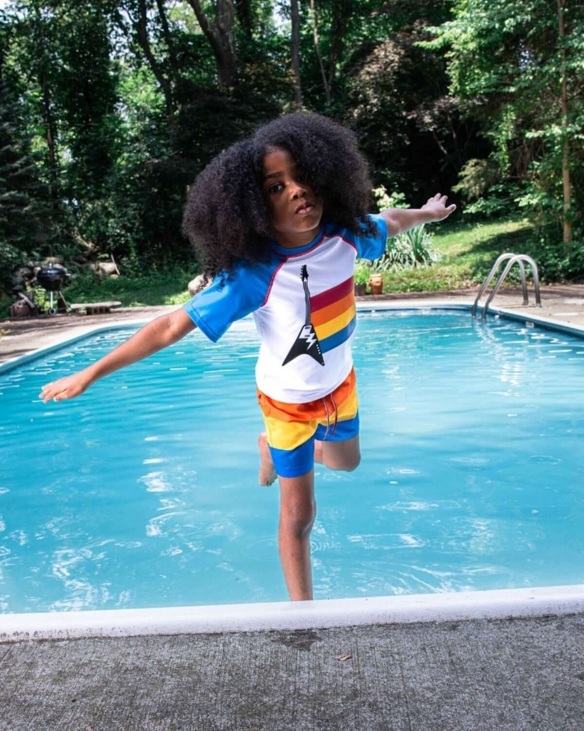 Kid wearing Guitar Strings Rash Guard, enjoying the pool with style in vibrant colors and cool guitar graphic.