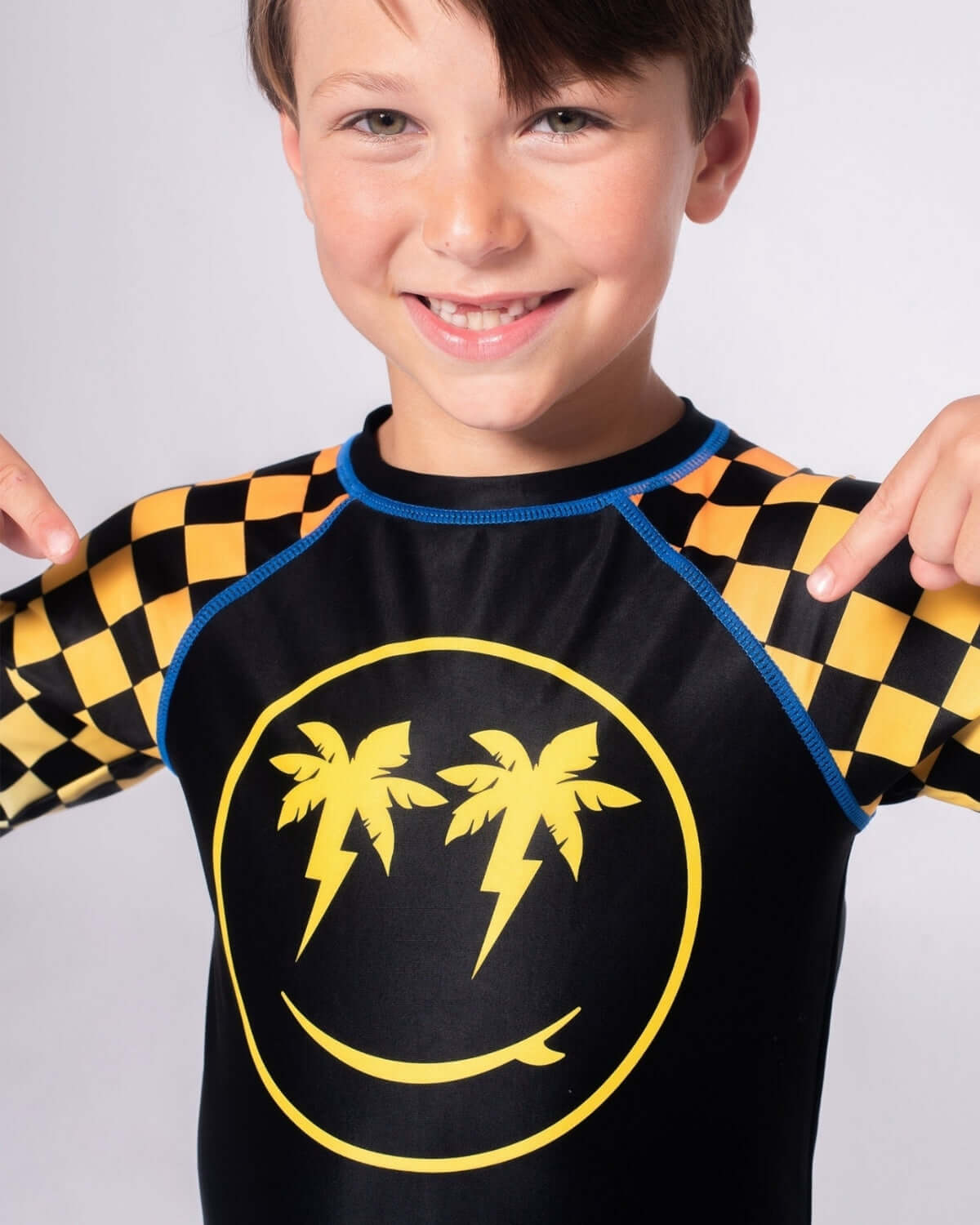 Happy Surfing Rash Guard featuring vibrant checkerboard design and a cheerful smiley face.