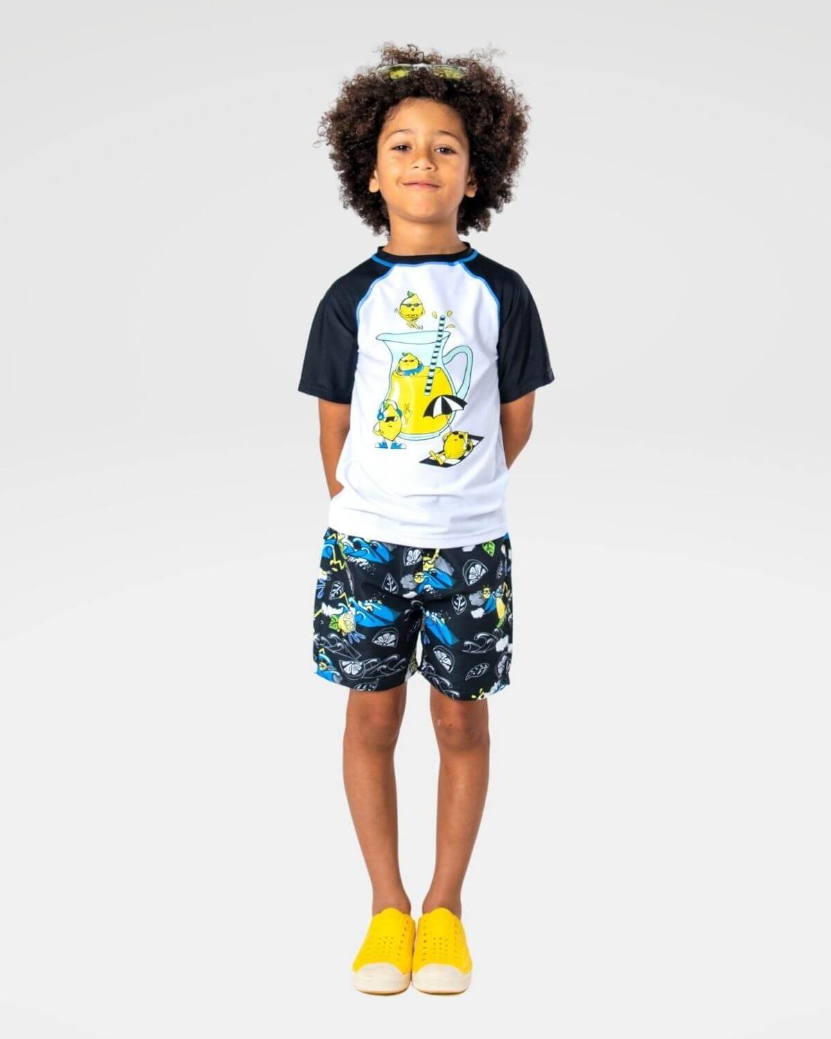 Boy wearing Lemon Chill Swim Trunks and gametime long sleeved rashguard with UPF 50+ protection.